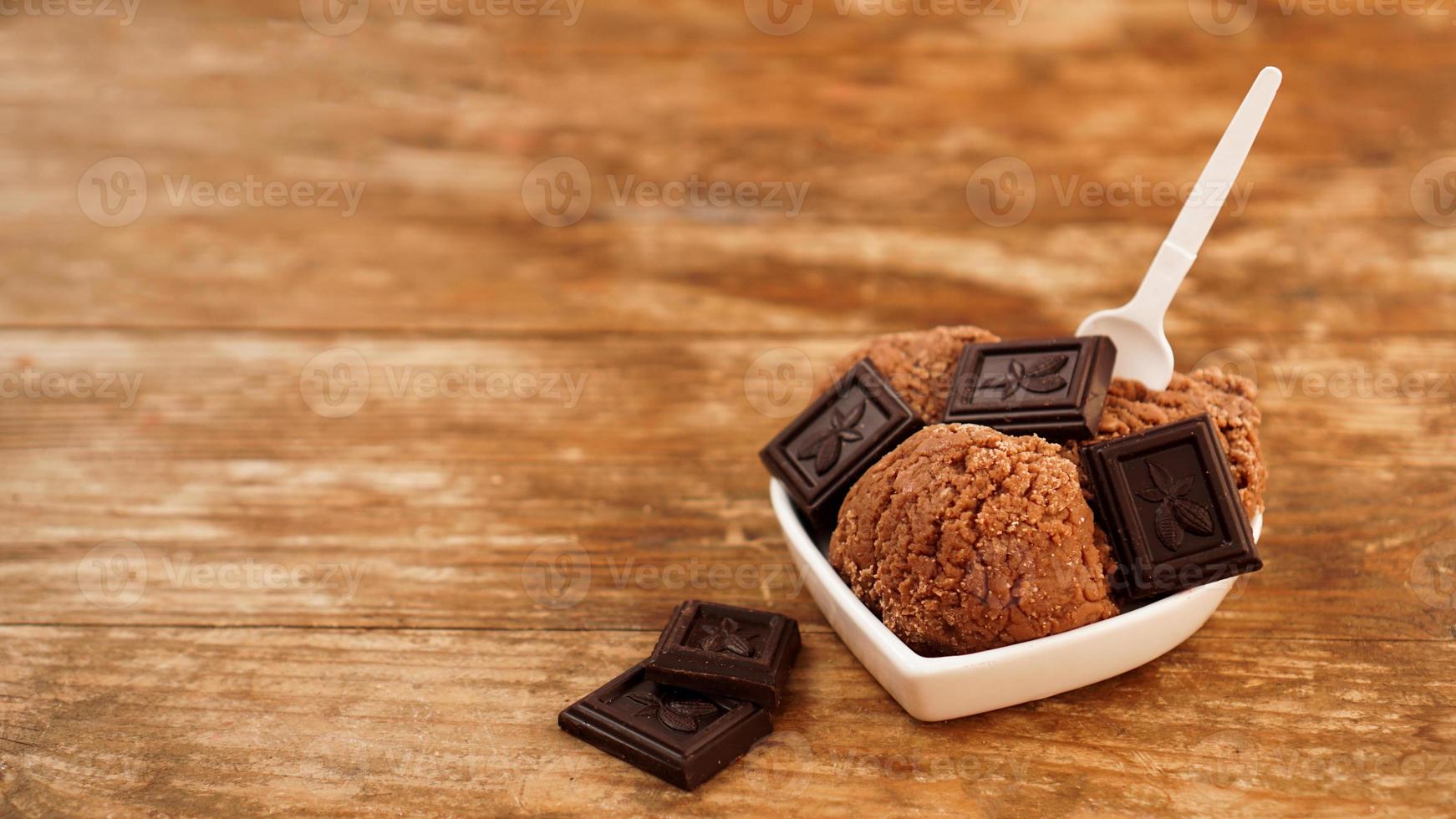 Helado de chocolate casero con trozos de chocolate en un recipiente blanco foto