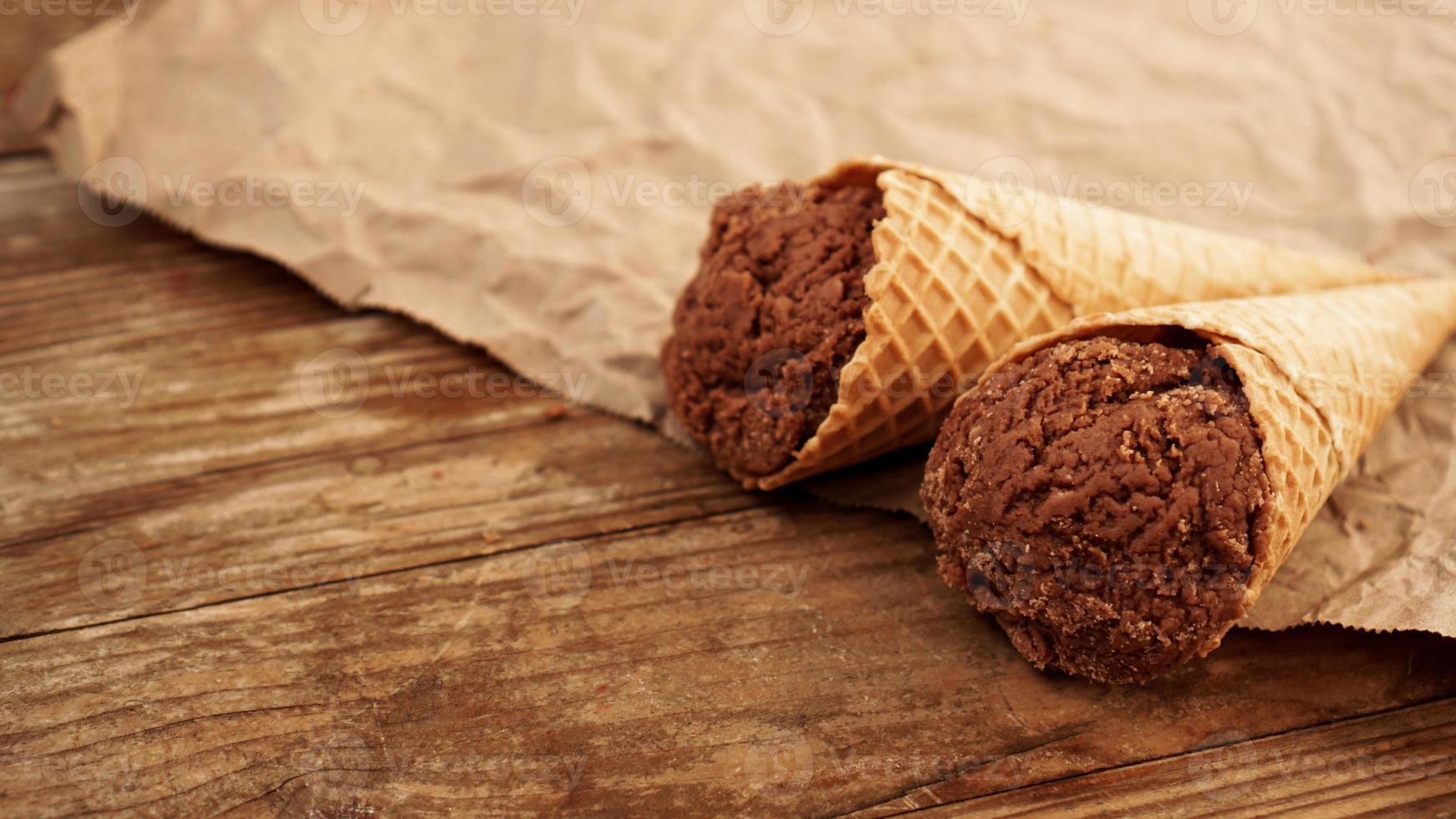 Chocolate ice cream in a waffle cone on craft paper photo