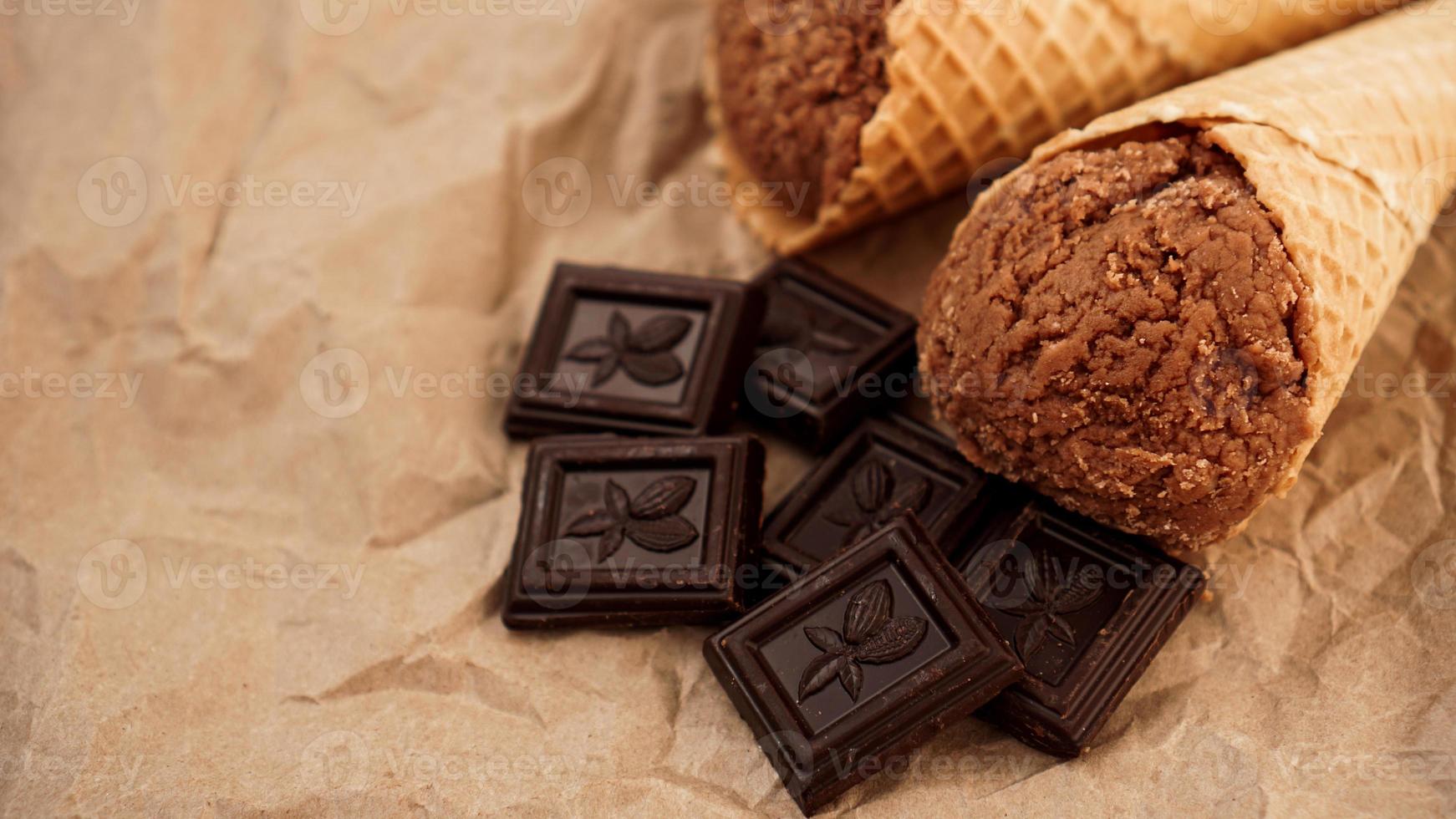 Chocolate ice cream in a waffle cone on craft paper photo