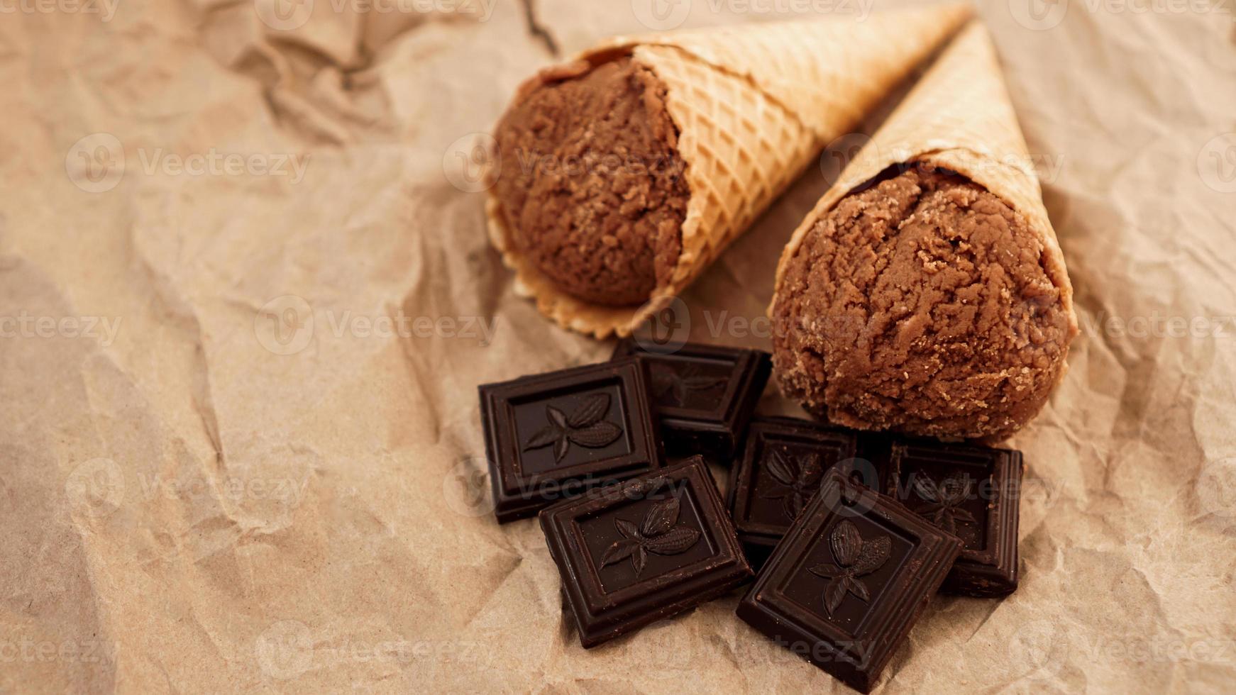 Chocolate ice cream in a waffle cone on craft paper photo