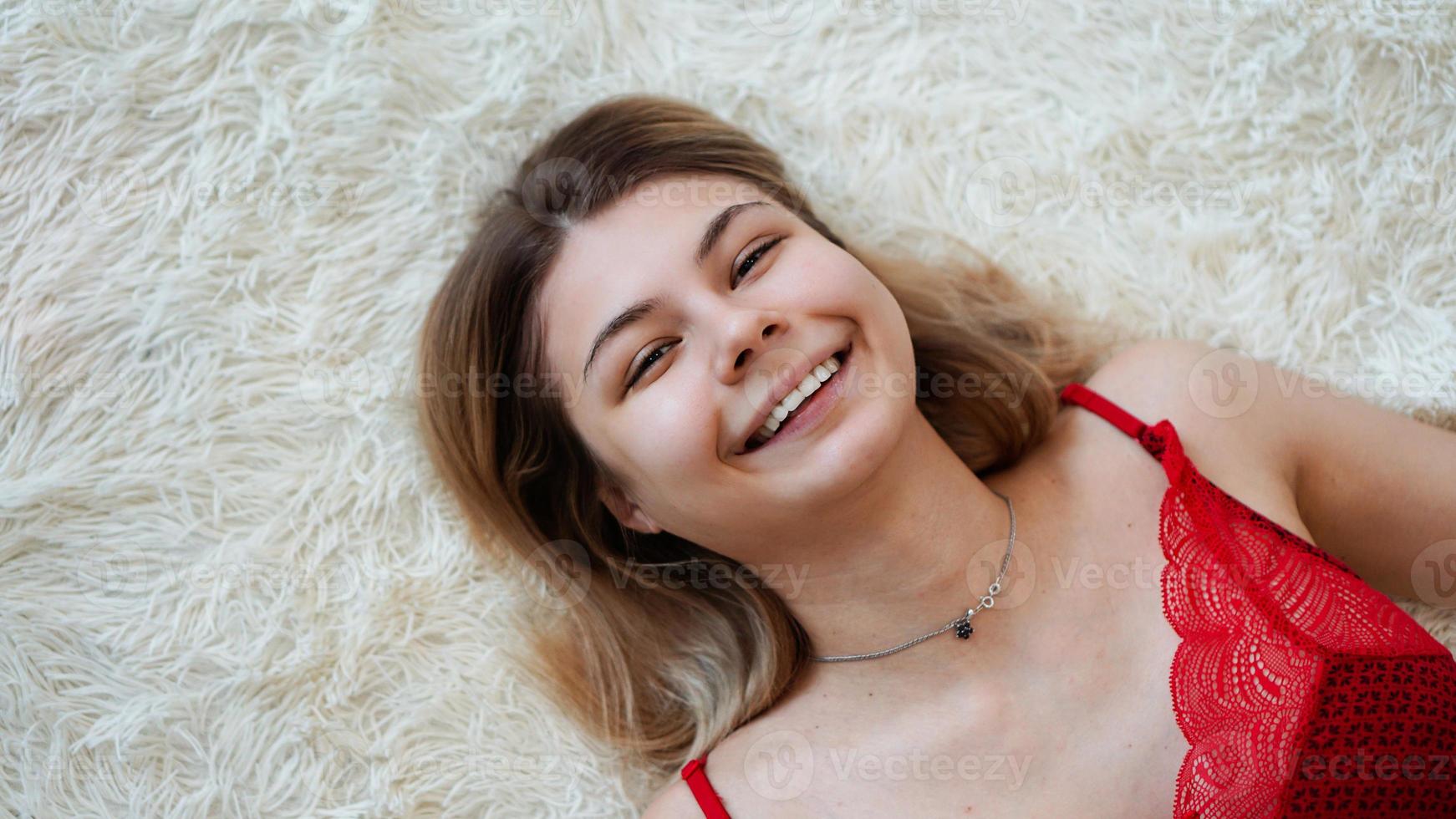 Beautiful young woman lying on a shaggy blanket. View from above. photo