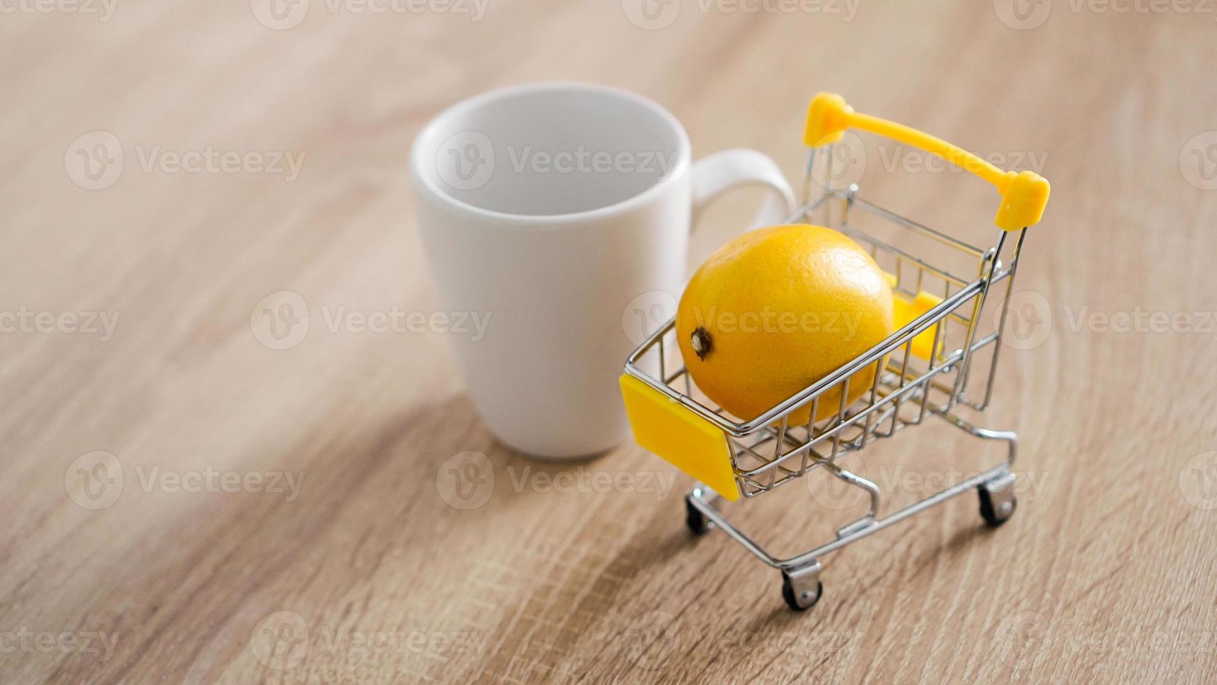 Lemon in a small shopping cart on the kitchen table photo