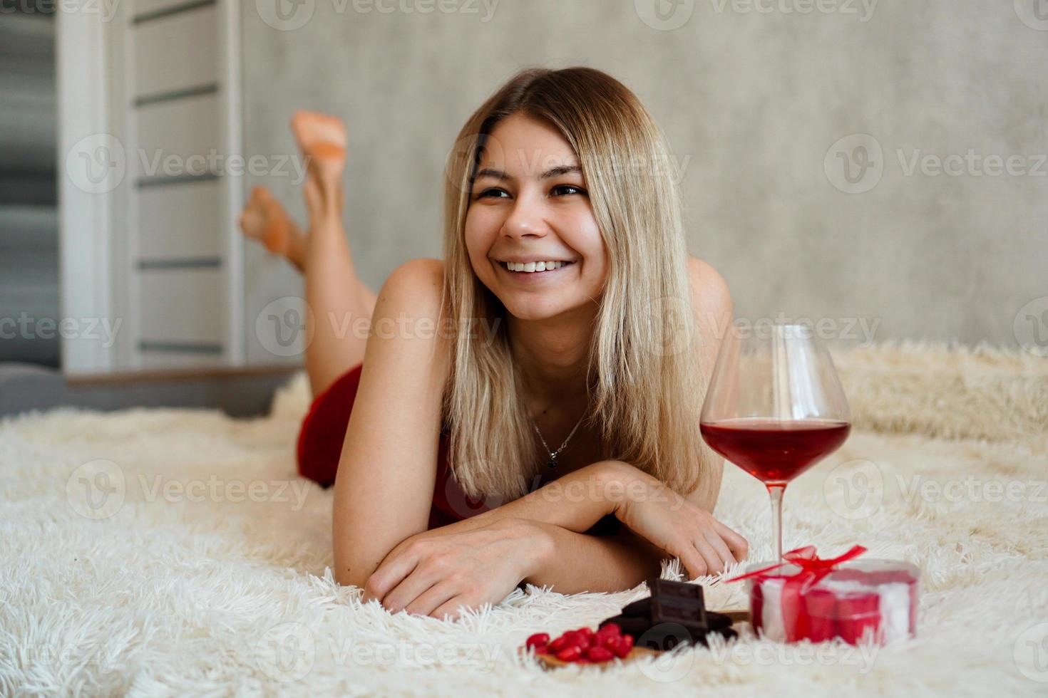 A beautiful smiling blonde lies in bed. Valentines Day Morning photo