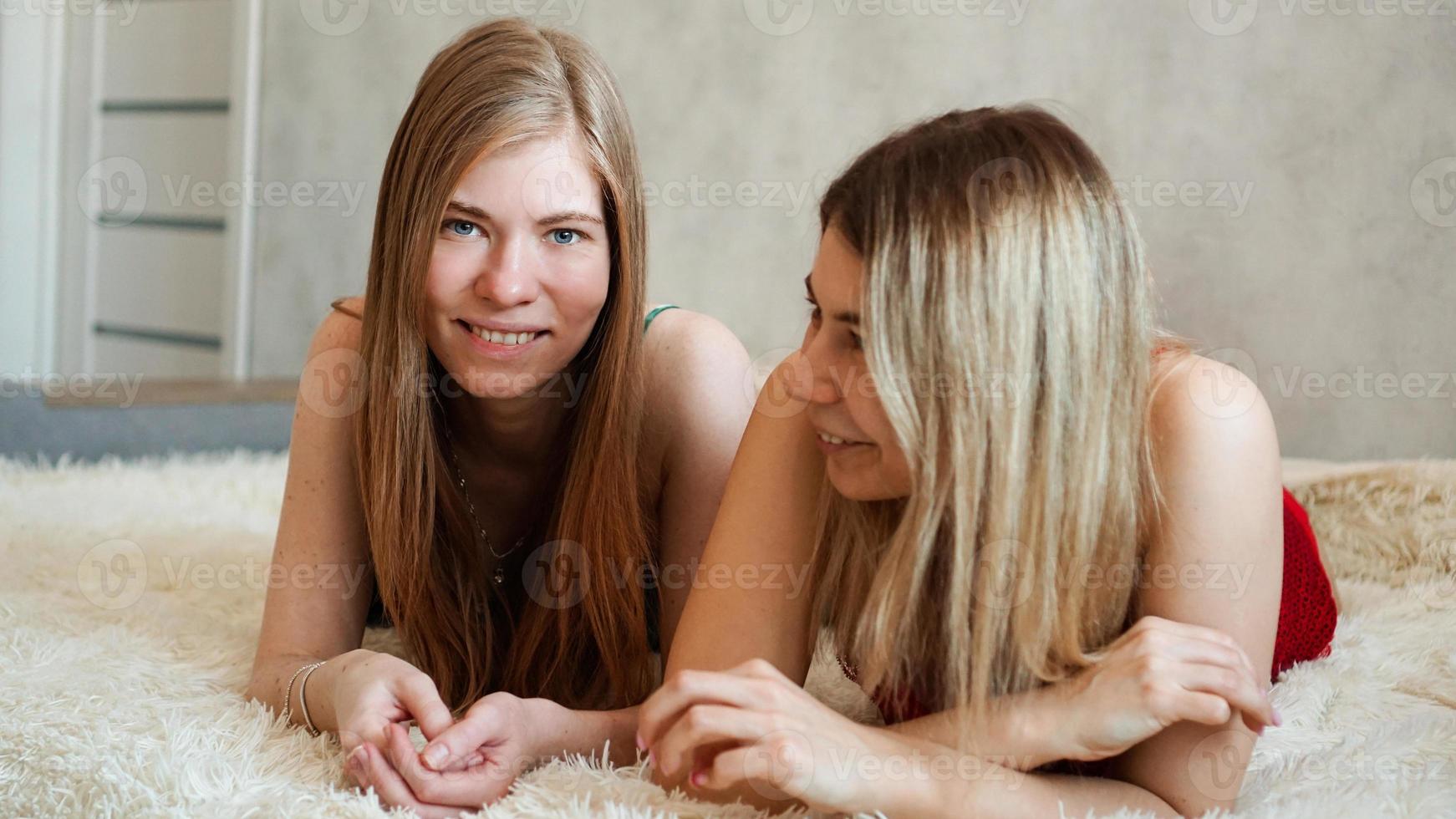 amigos felices acostados en la cama y riendo foto