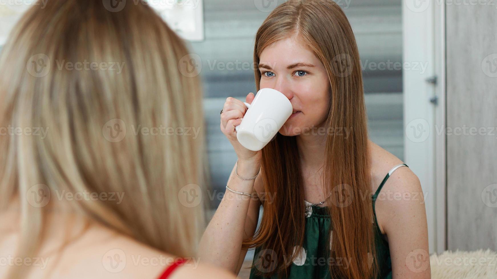 Retrato de dos chicas divertidas en pijama divirtiéndose foto