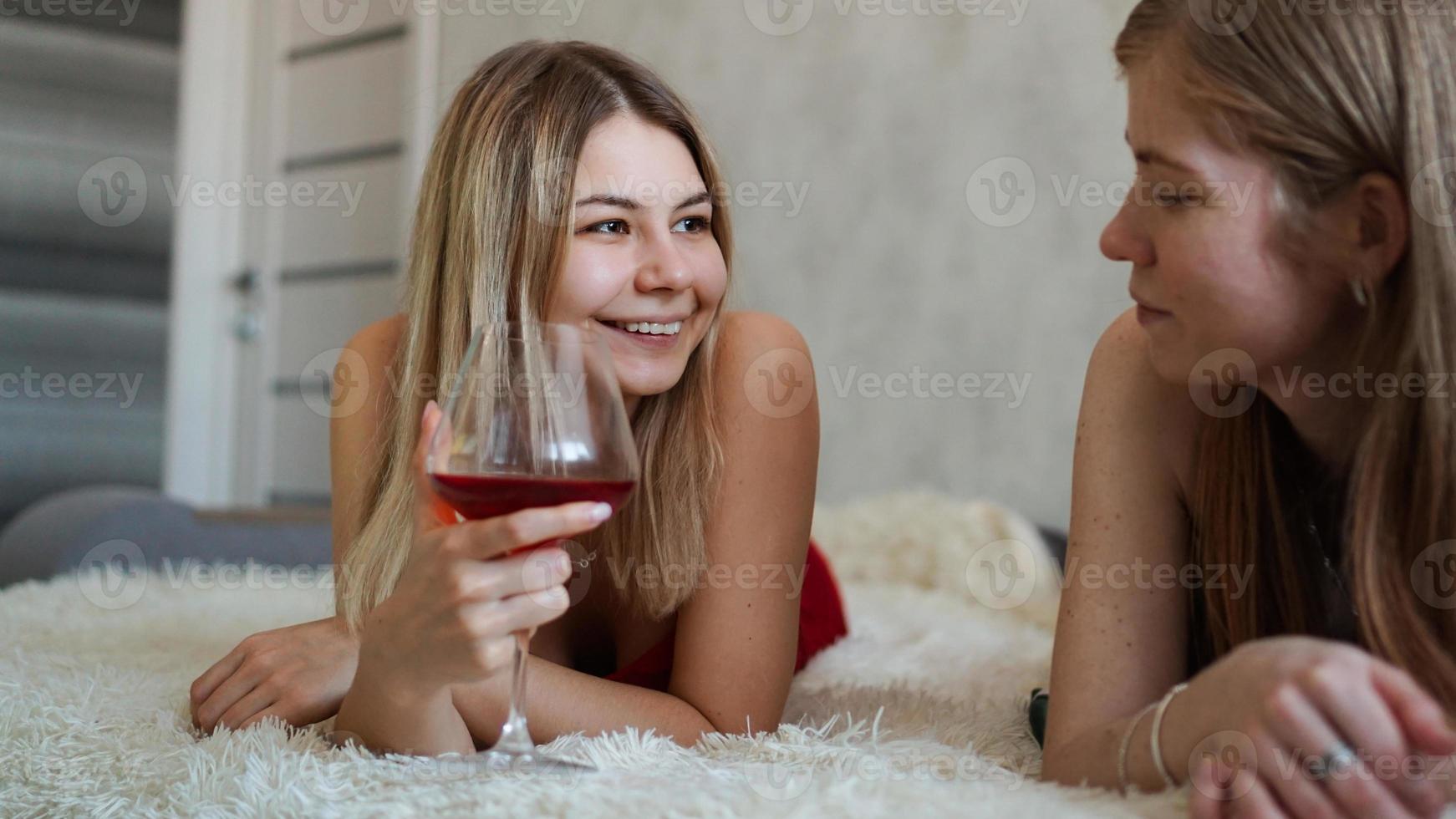 Two friends are lying on the couch and chatting photo