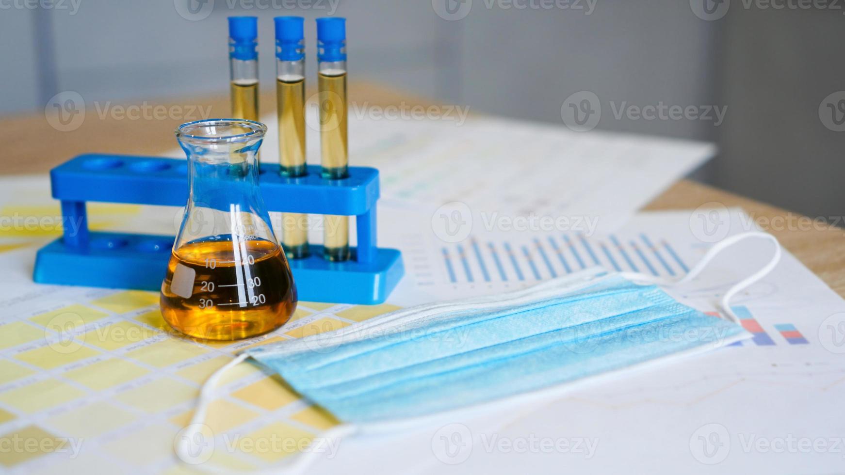 Flask and test tubes with urine on medical color schemes photo