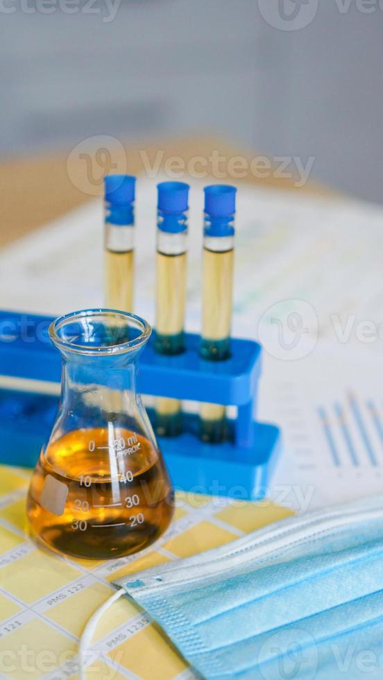 Flask and test tubes with urine on medical color schemes photo
