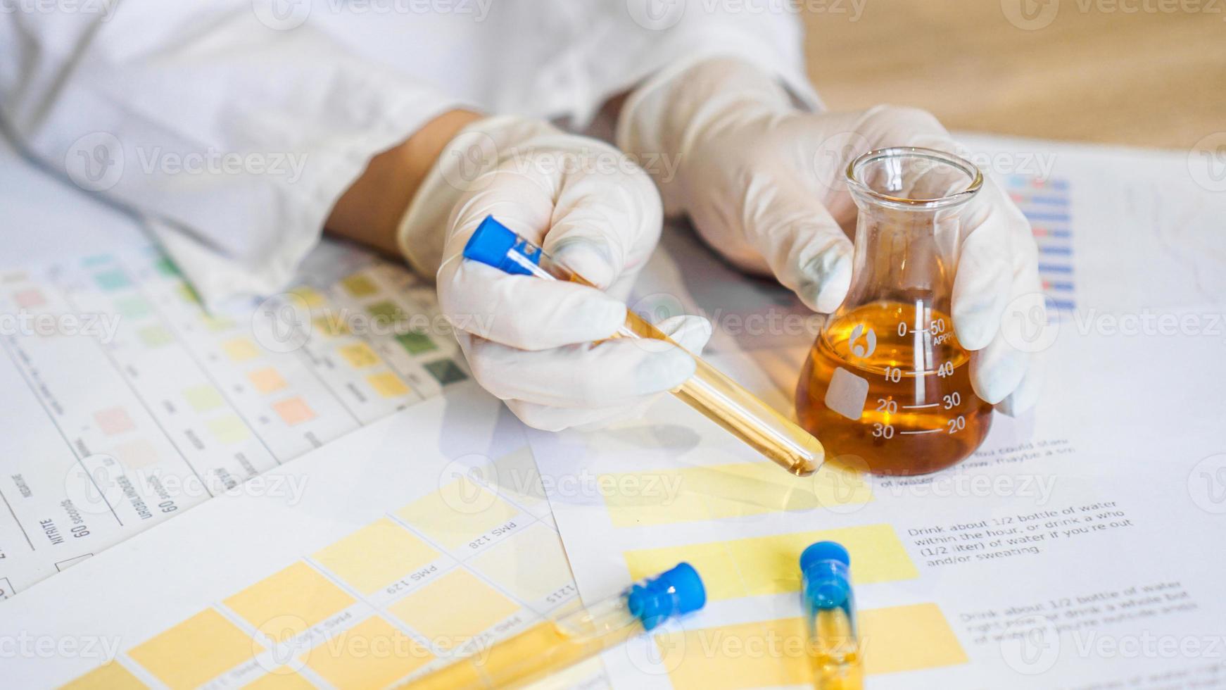 Mujer haciendo análisis de orina con material de ph en laboratorio foto