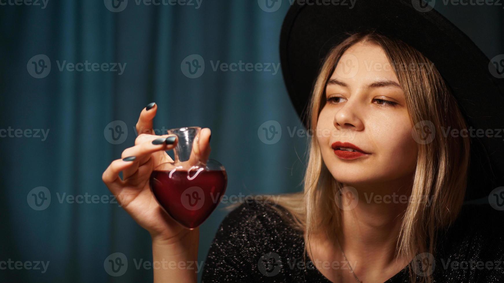 Cropped image of woman holding heart shaped glass jar of love potion photo
