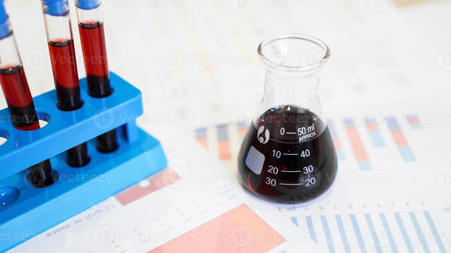 Test tubes on a stand and a flask with red blood photo