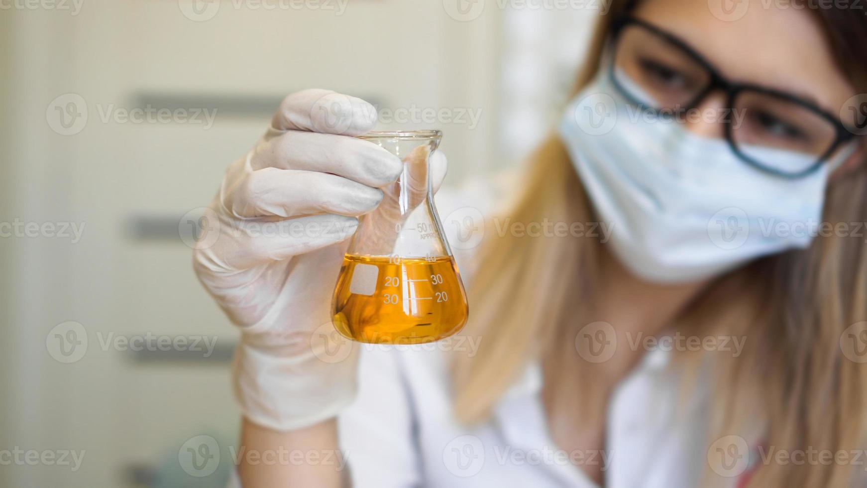 A woman holds a flask with a urine test photo