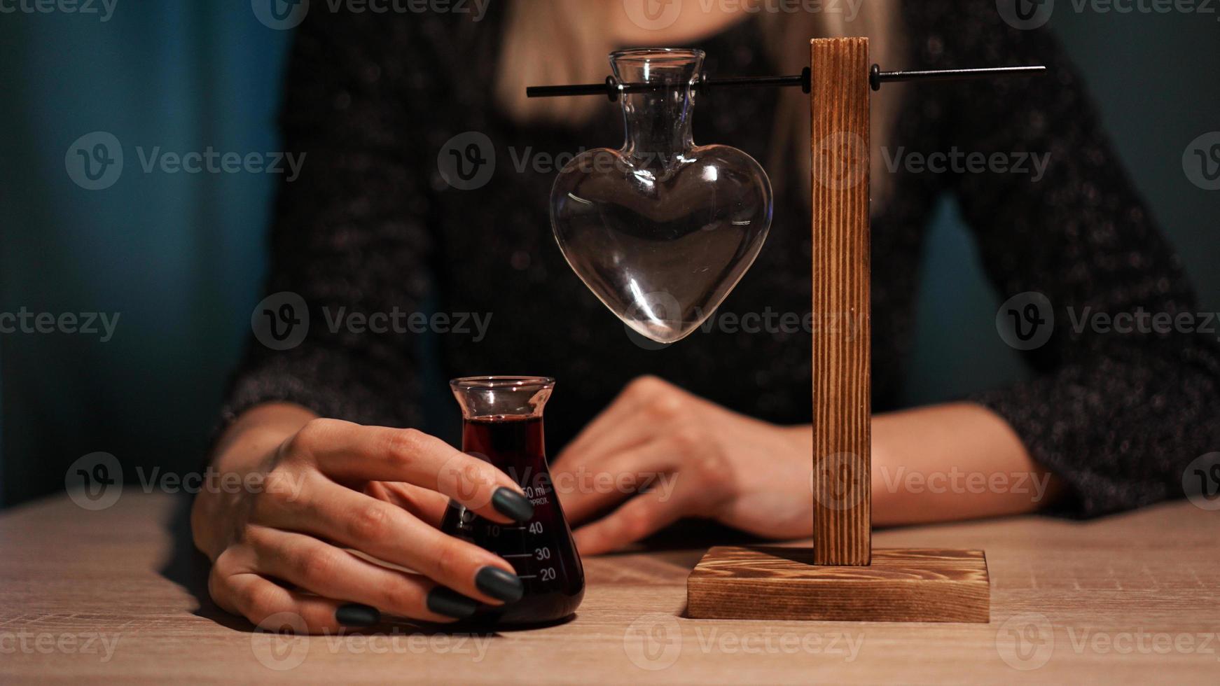 The woman witch prepares a potion. Red love potion photo