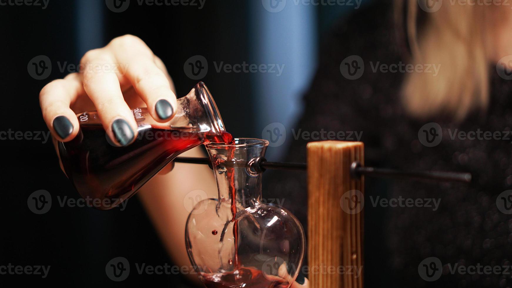 la mujer bruja prepara una poción. poción de amor roja foto