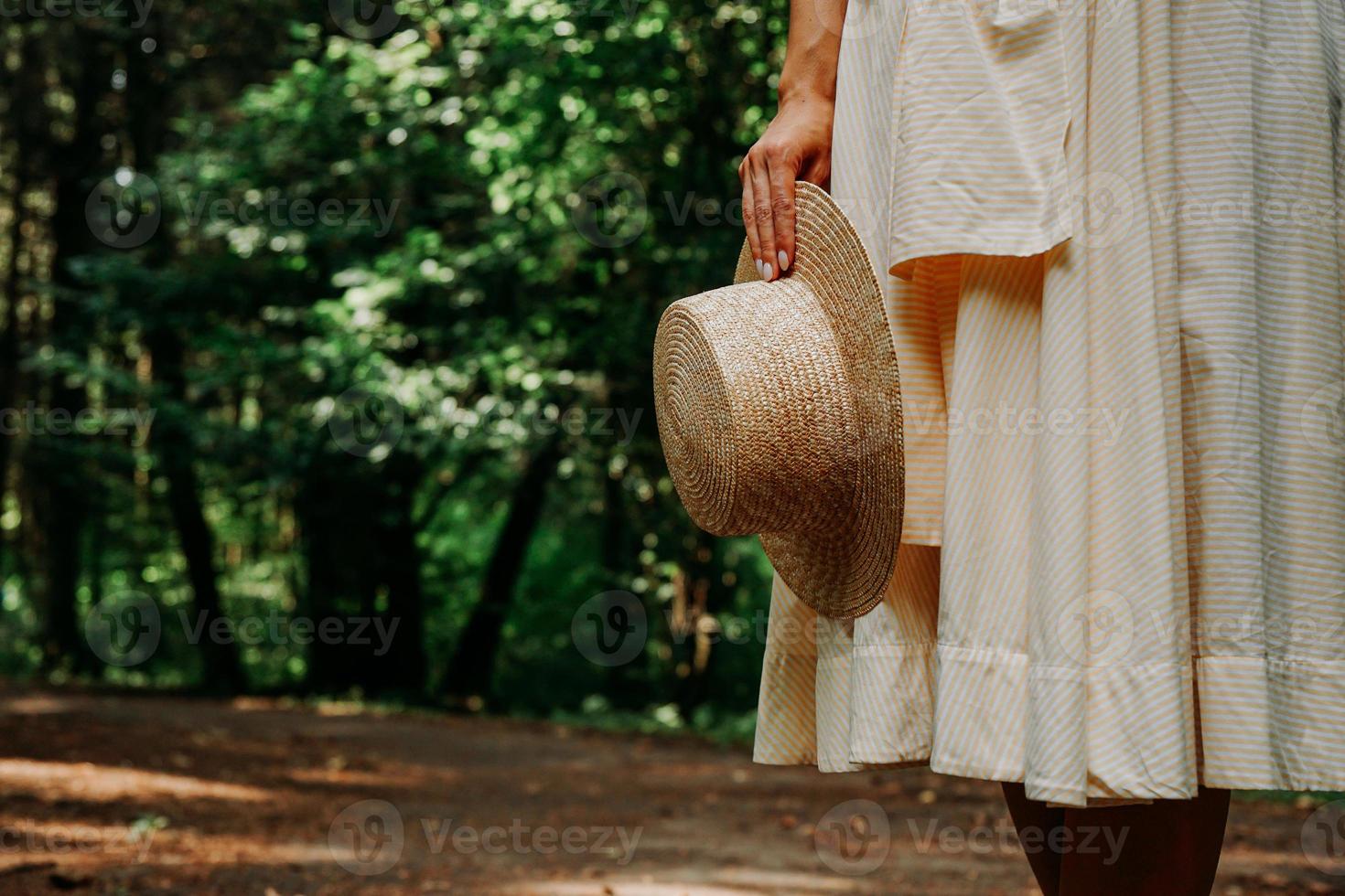 Close-up photo of a woman's hand holding a straw hat