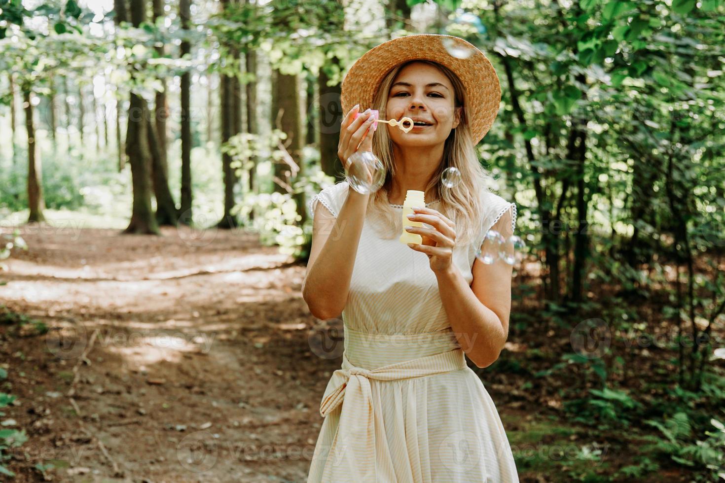 Cute blonde woman blowing soap bubbles. photo