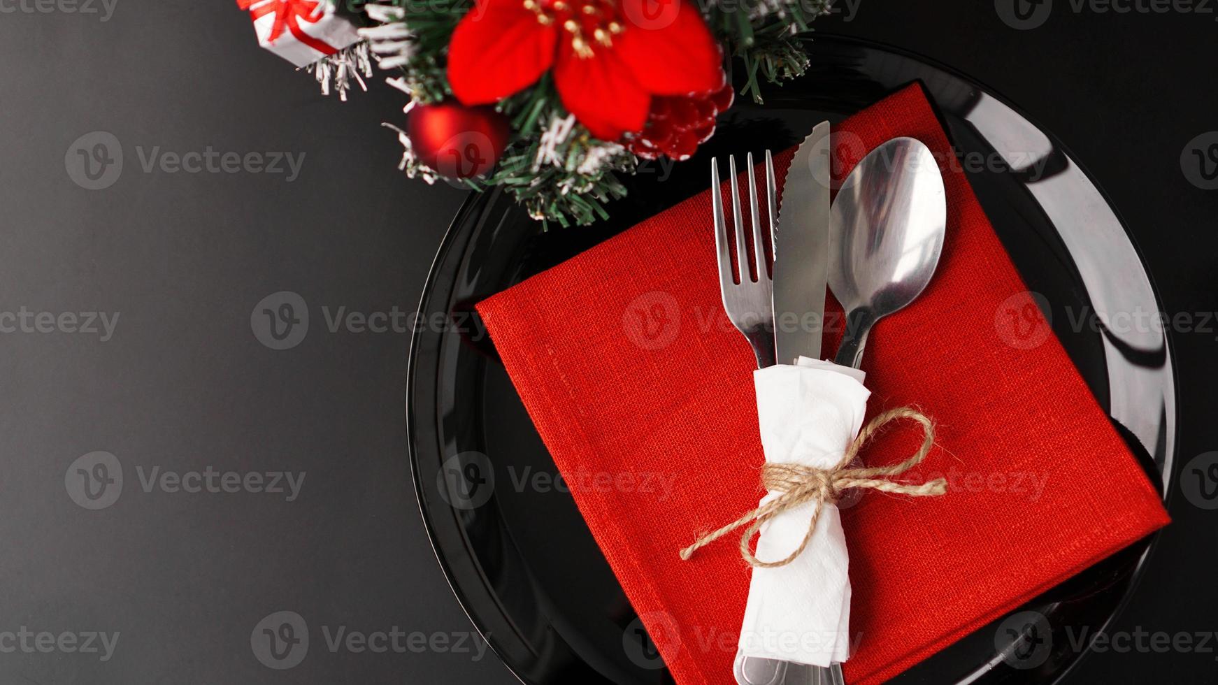 Ajuste para la cena navideña en mesa negra con decoración foto