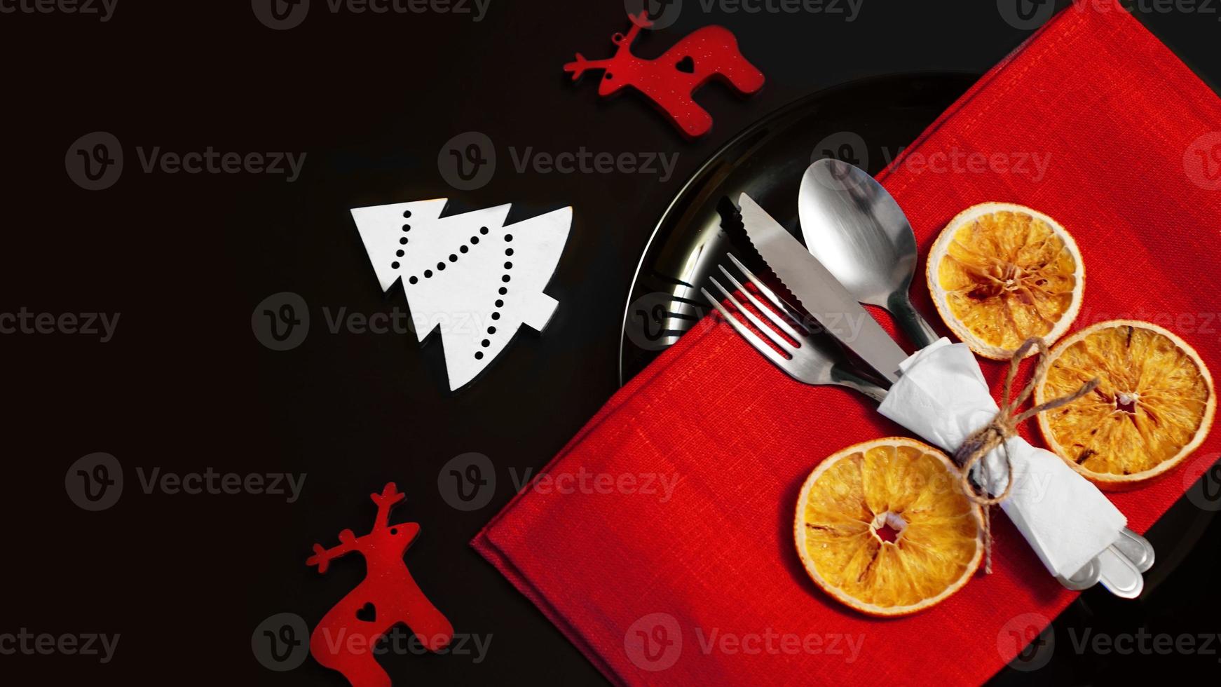Setting for festive Christmas dinner on black table with decoration photo