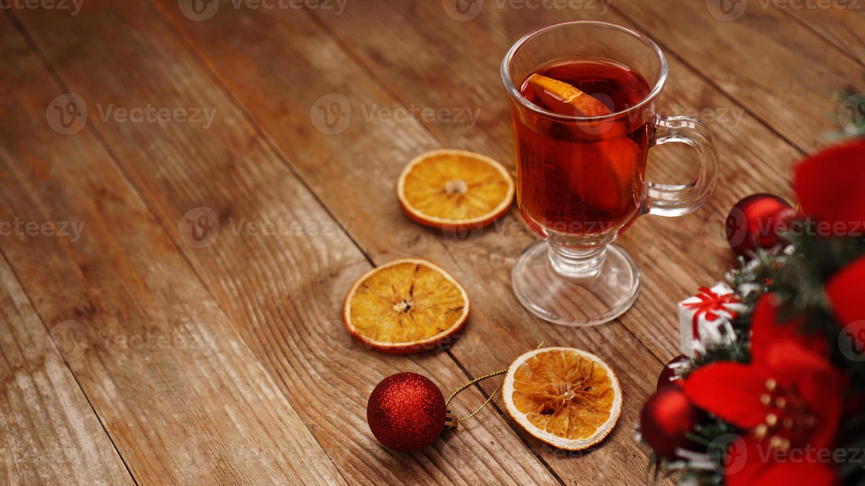 Navidad vino caliente en copa de cristal sobre una mesa de madera foto