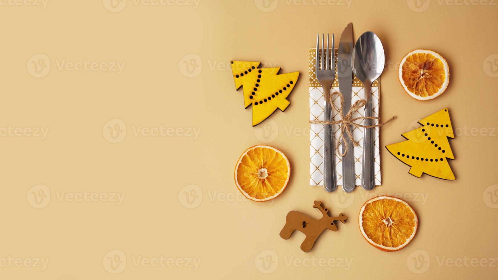 Ajuste de la mesa con estatuillas navideñas de madera y naranja seca foto