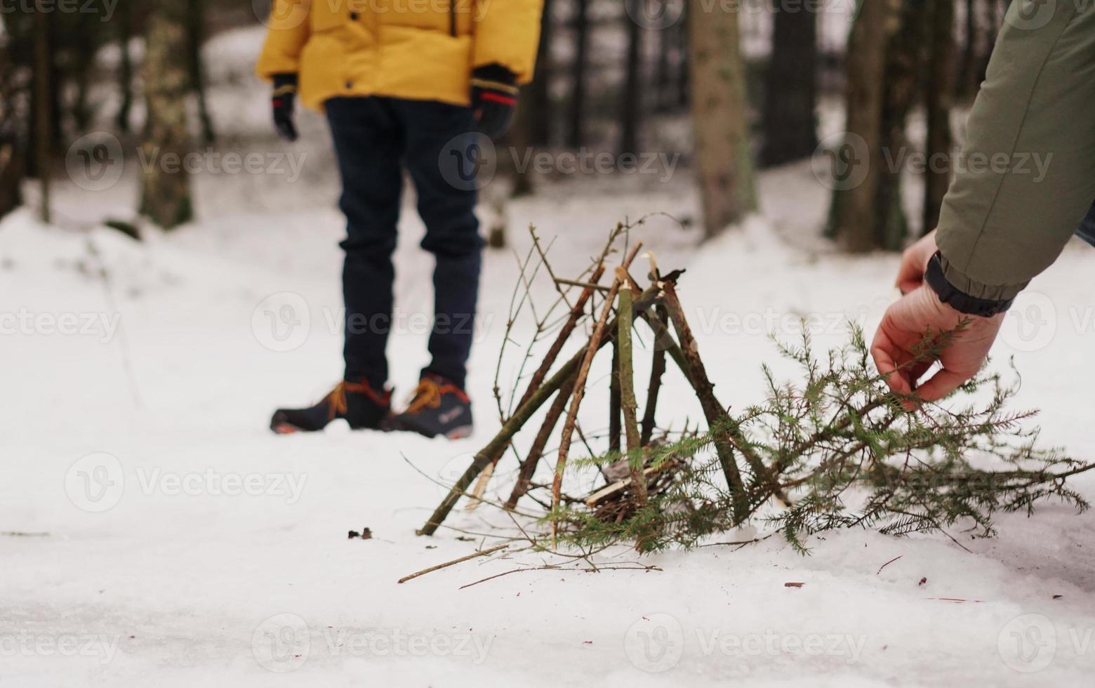 Tourists at a halt. Preparation for making a fire from spruce branches photo