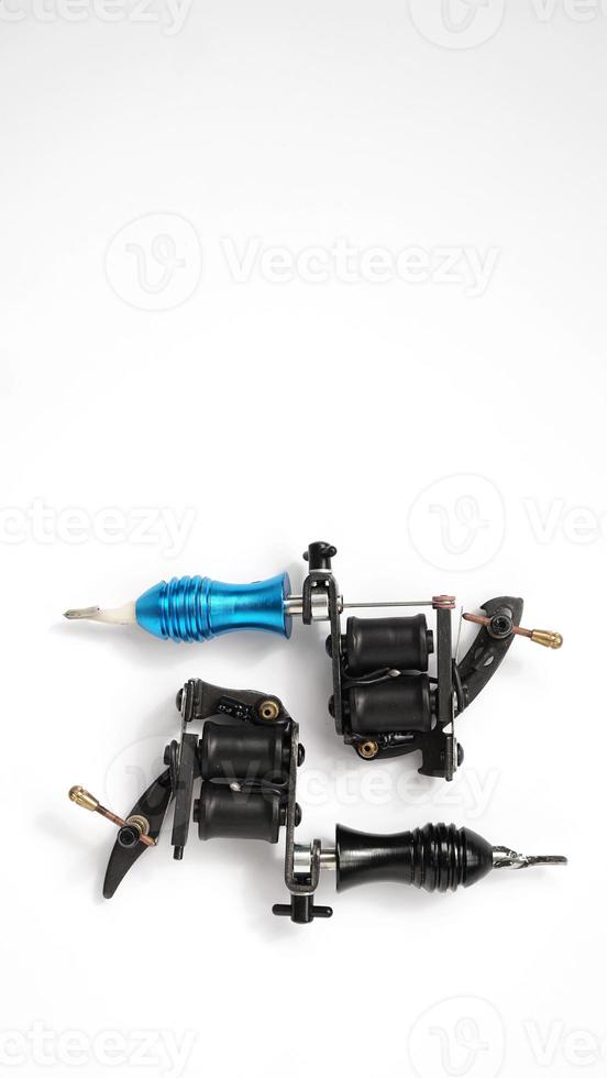 Two tattoo machines on a white background - vertical photo