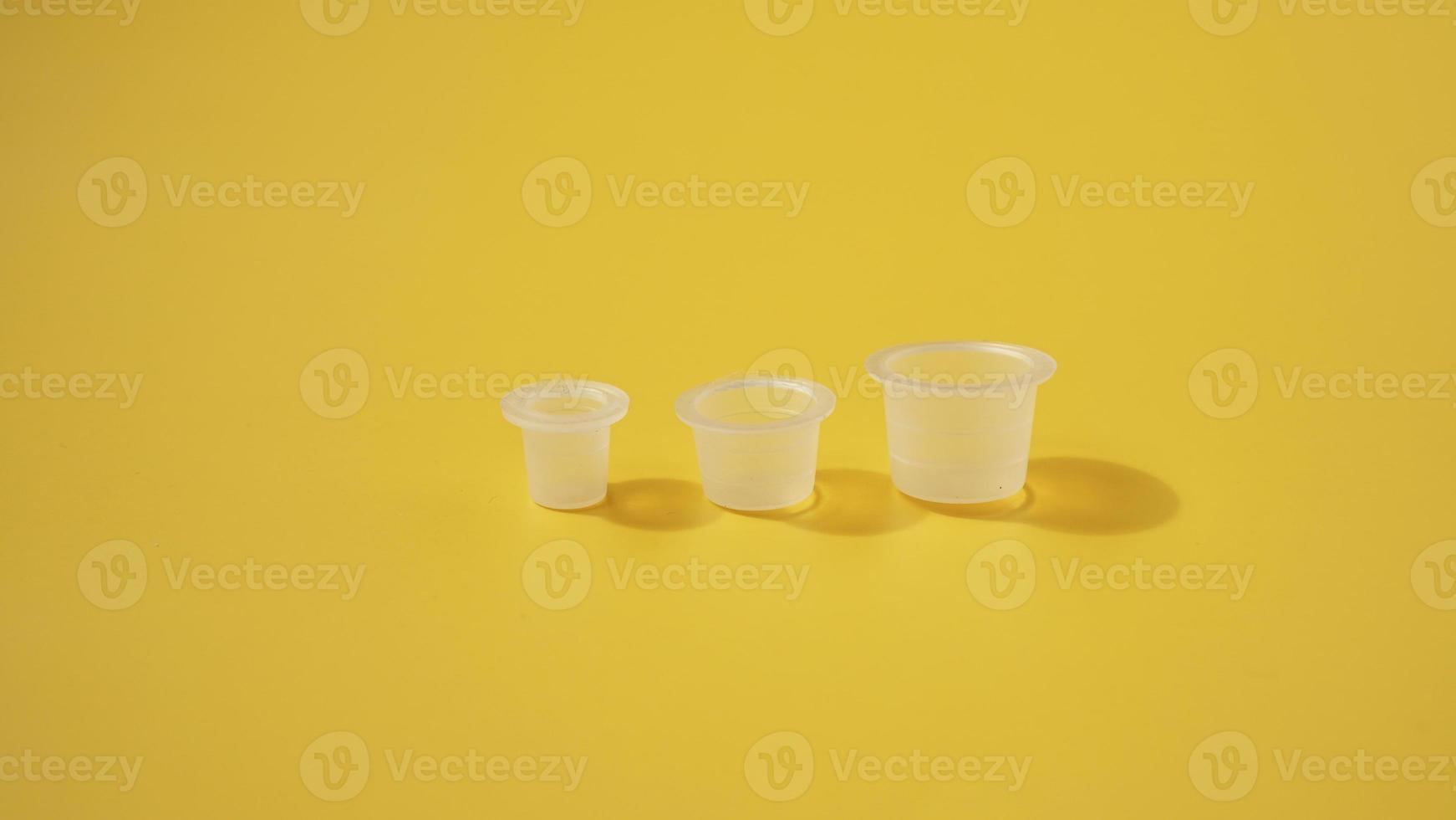 Three ink plastic caps on yellow background photo