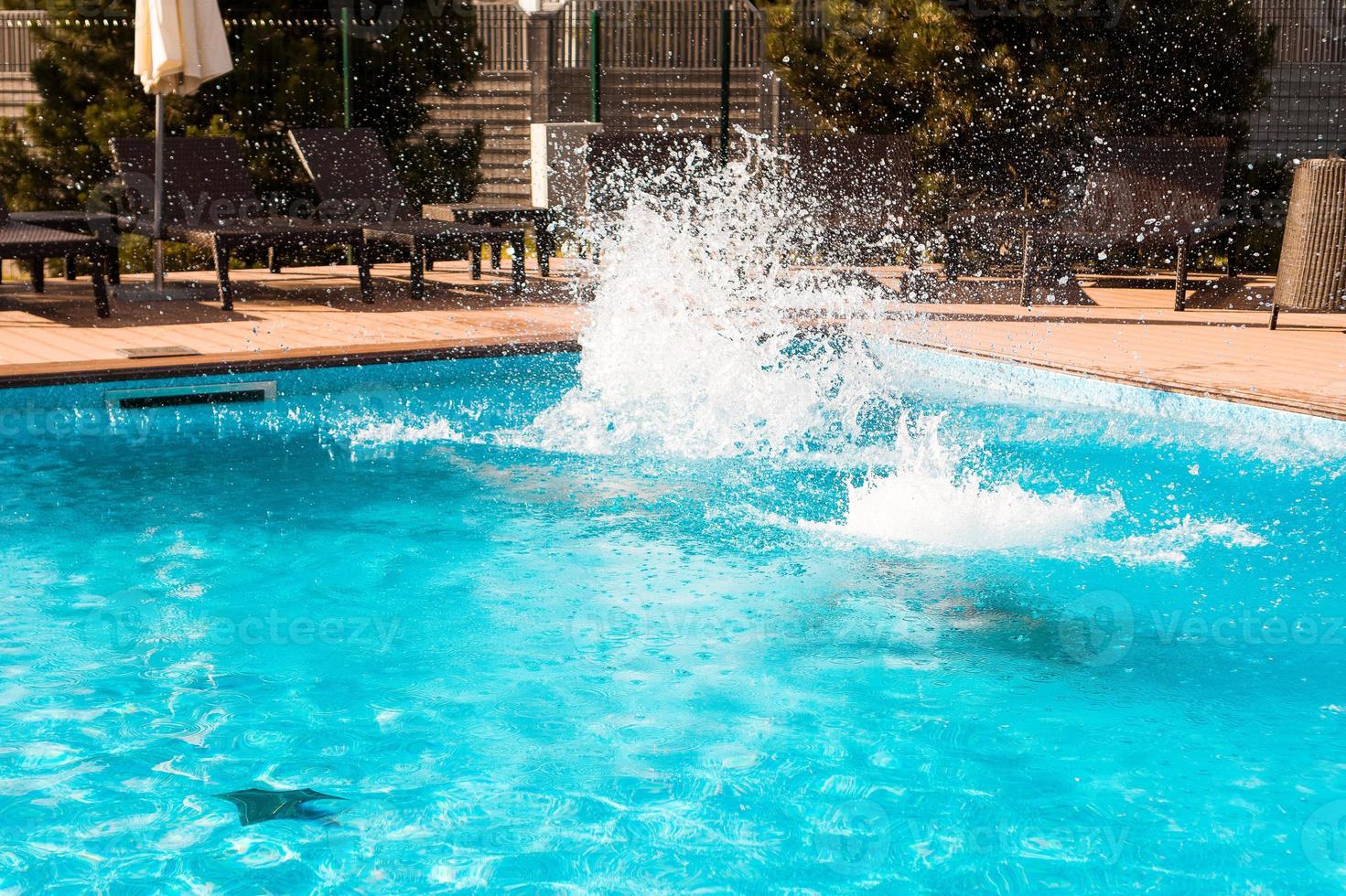 Pool fun. Jumping into the outdoor swimming pool photo