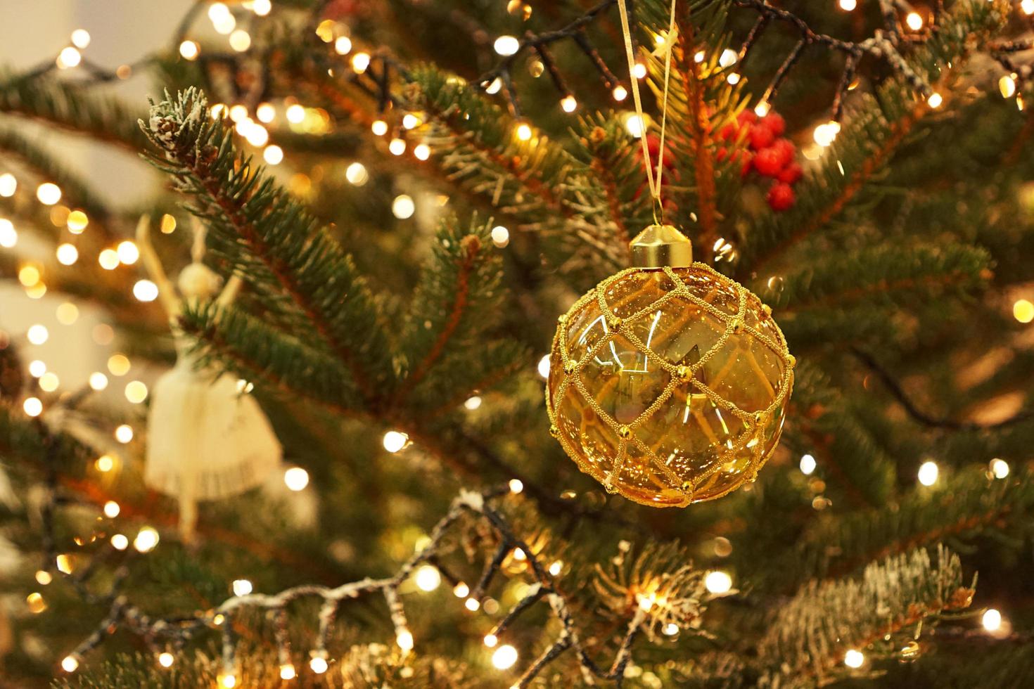 Decoración navideña en forma de bola en árbol real. foto