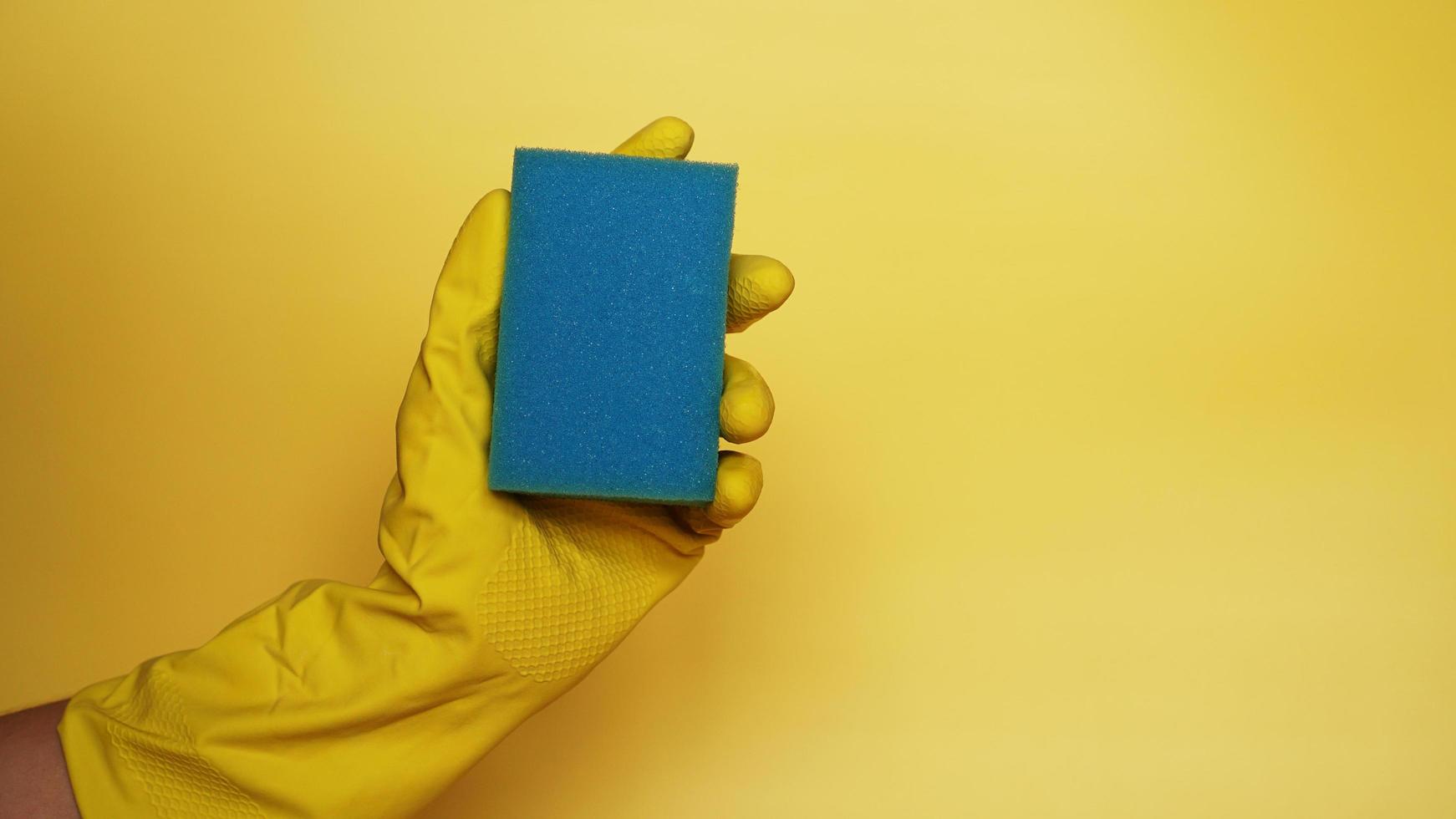 Sponge for washing dishes in hand. Hand in a latex glove isolated. photo