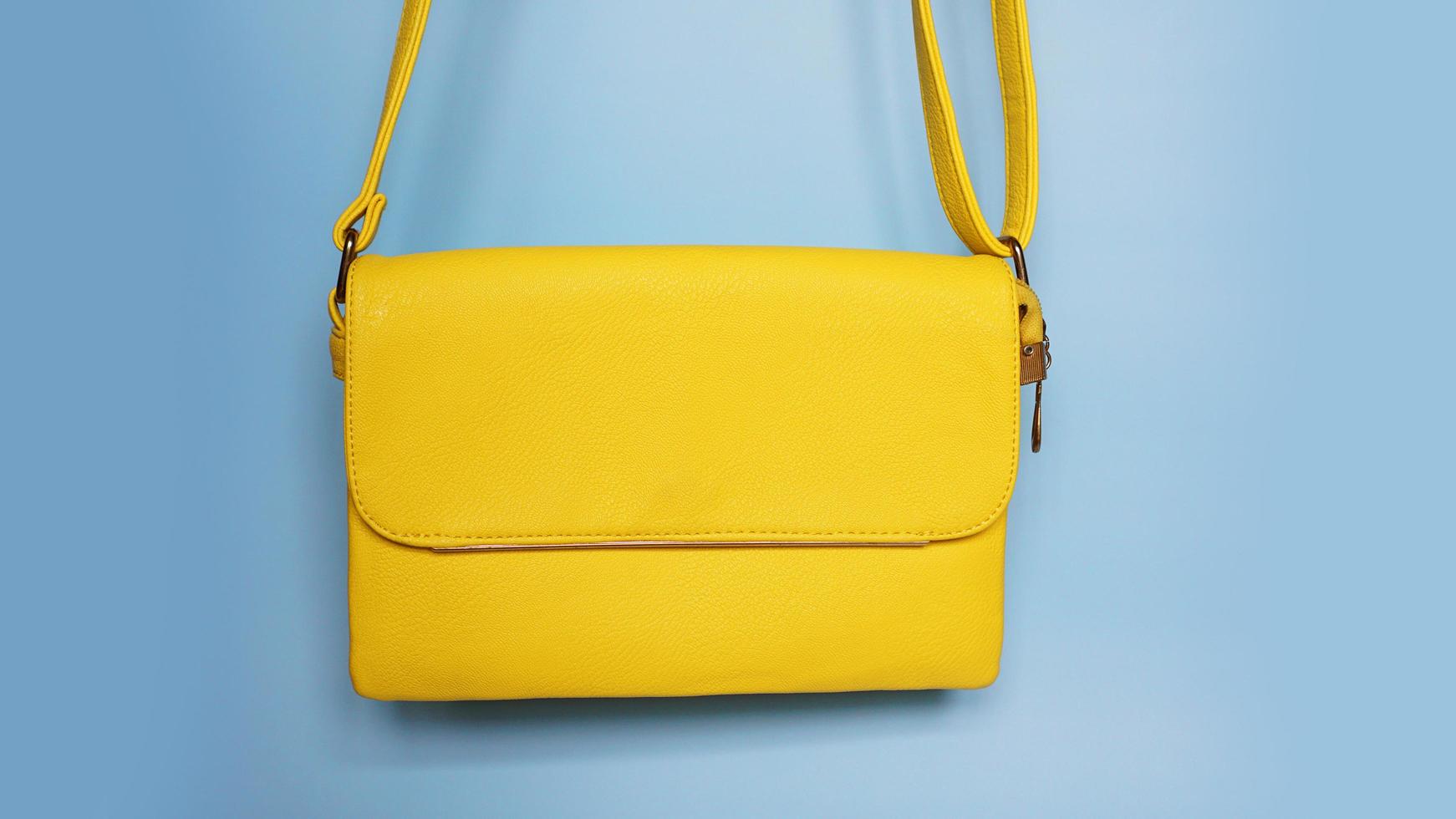 Yellow fashion female woman purse handbag on blue photo