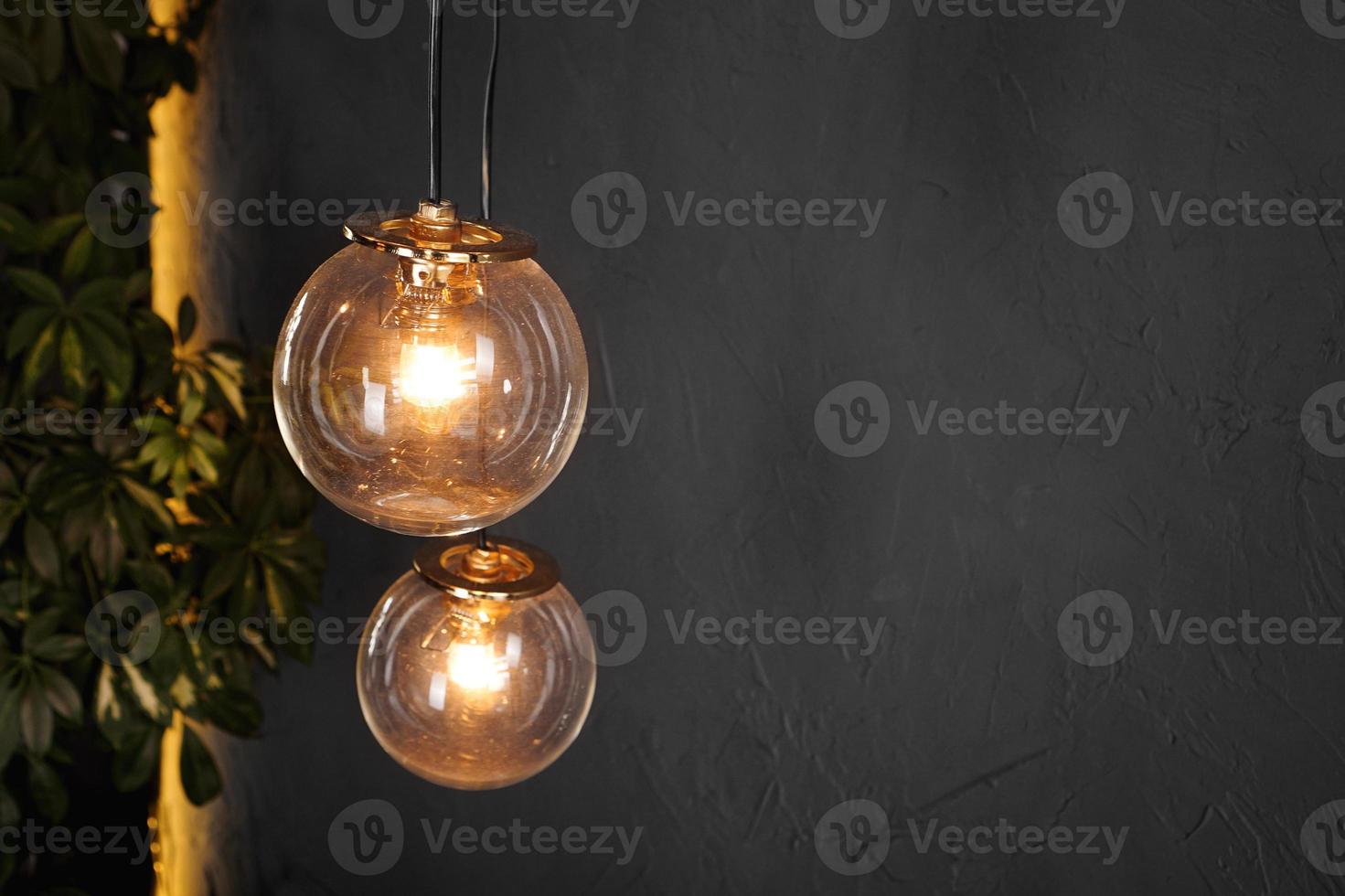 Decorative light tungsten bulbs against wall background photo