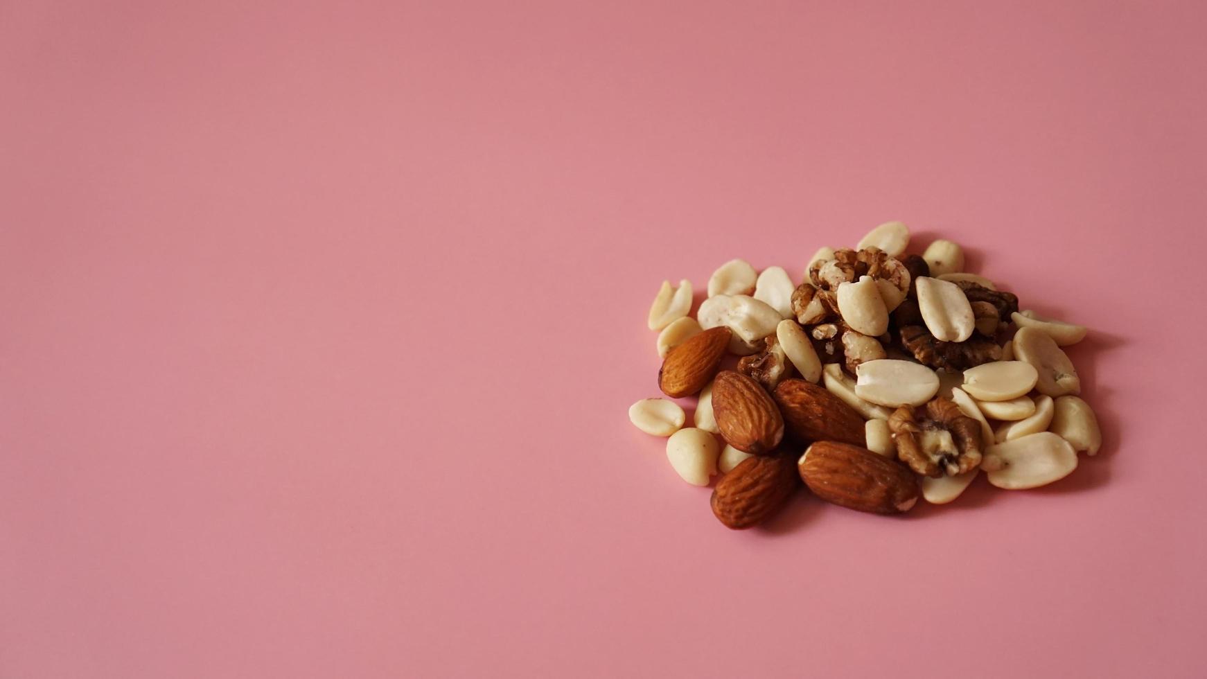 Un puñado de nueces sobre fondo rosa brillante, fondo de color foto