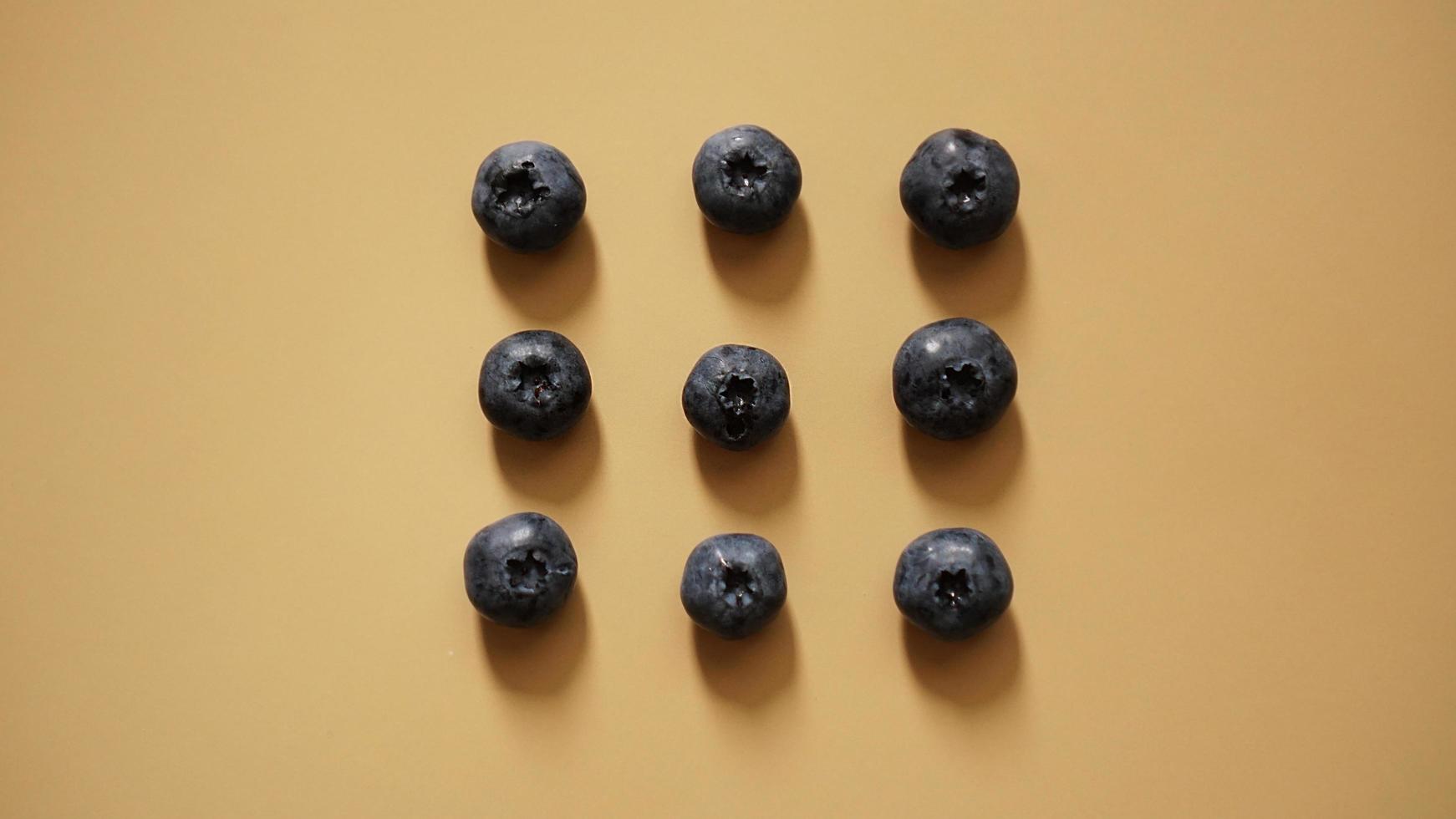 Blueberries are laid out in rows on a gold background photo