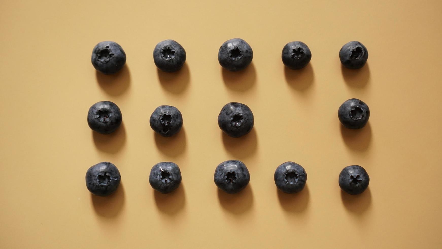 Blueberries are laid out in rows on a gold background photo