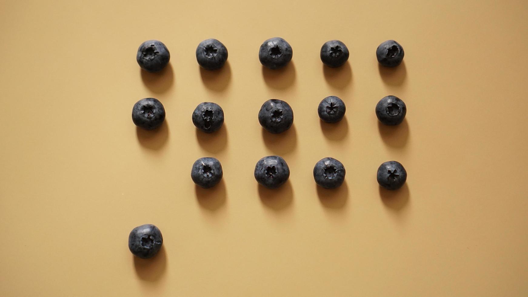 Blueberries are laid out in rows on a gold background photo