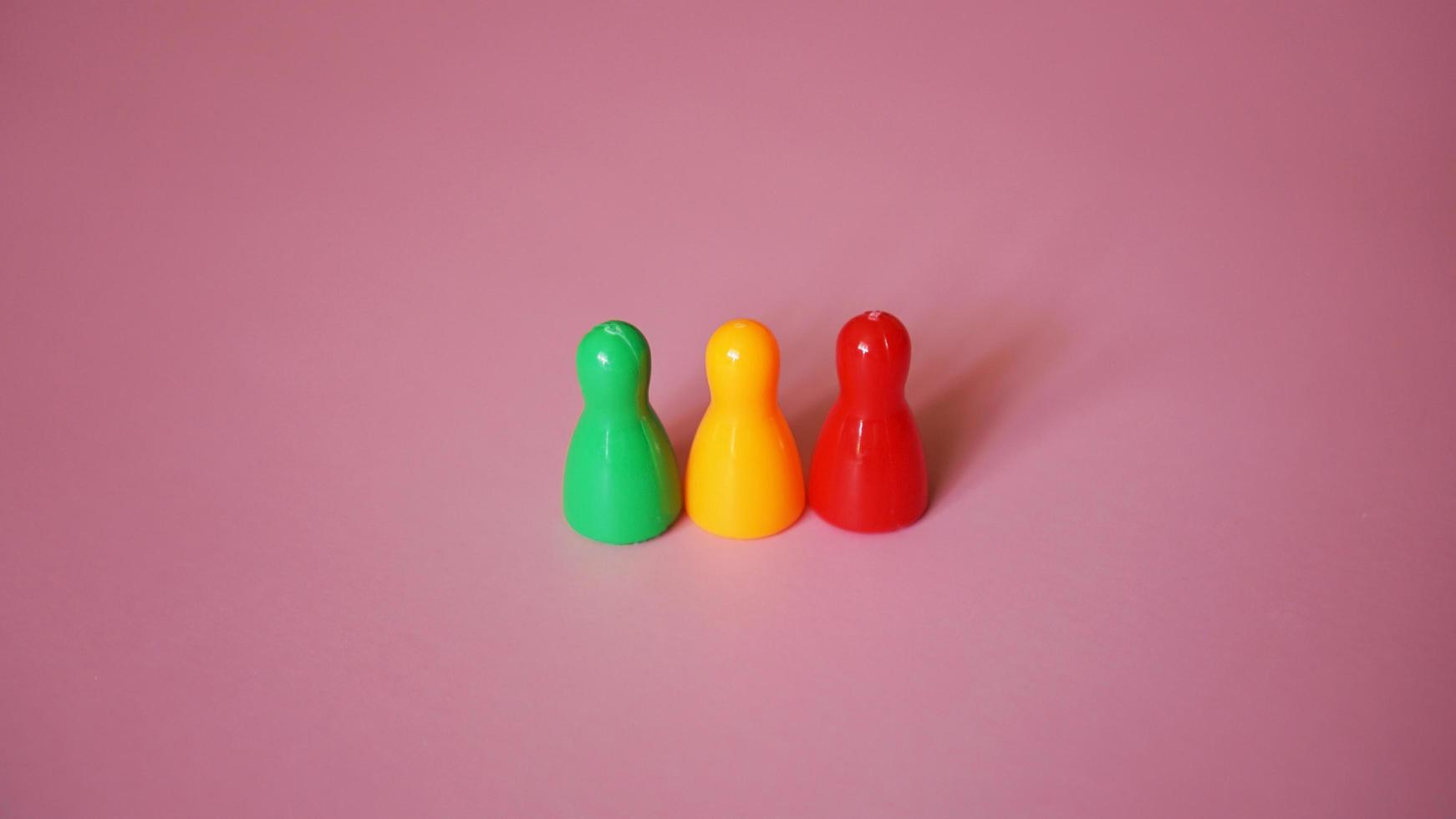 Board game figures on pink background photo