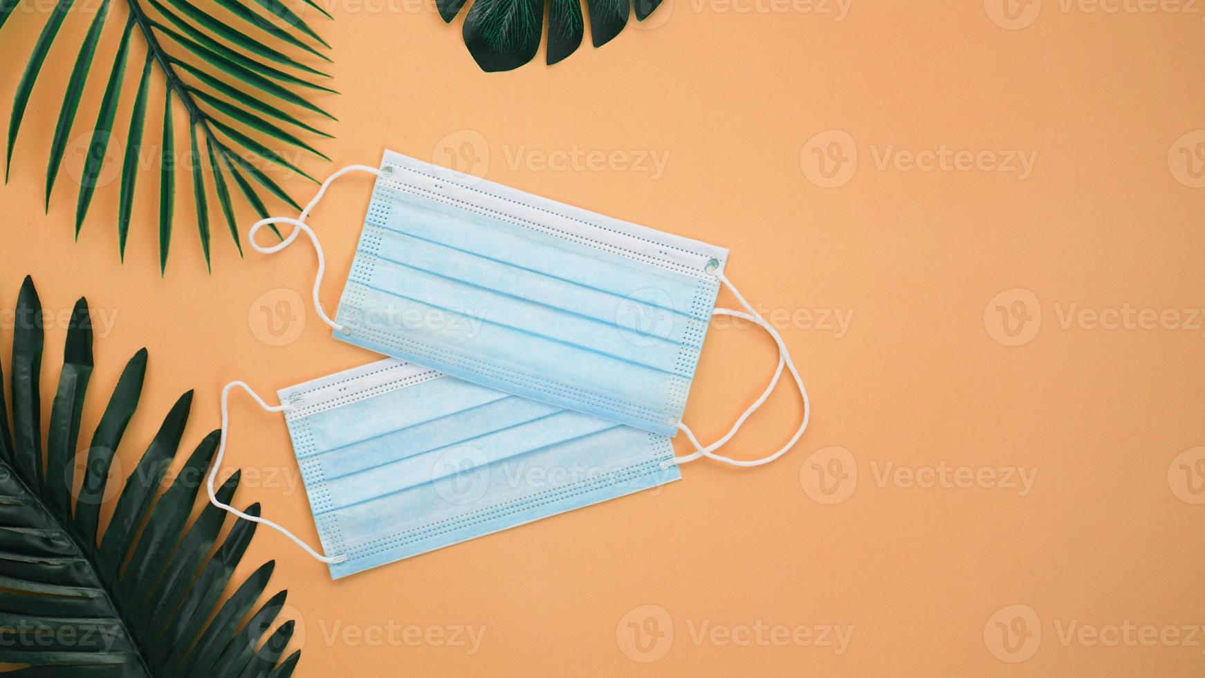 Protective medical masks with palm leaves. Vacation during the virus photo