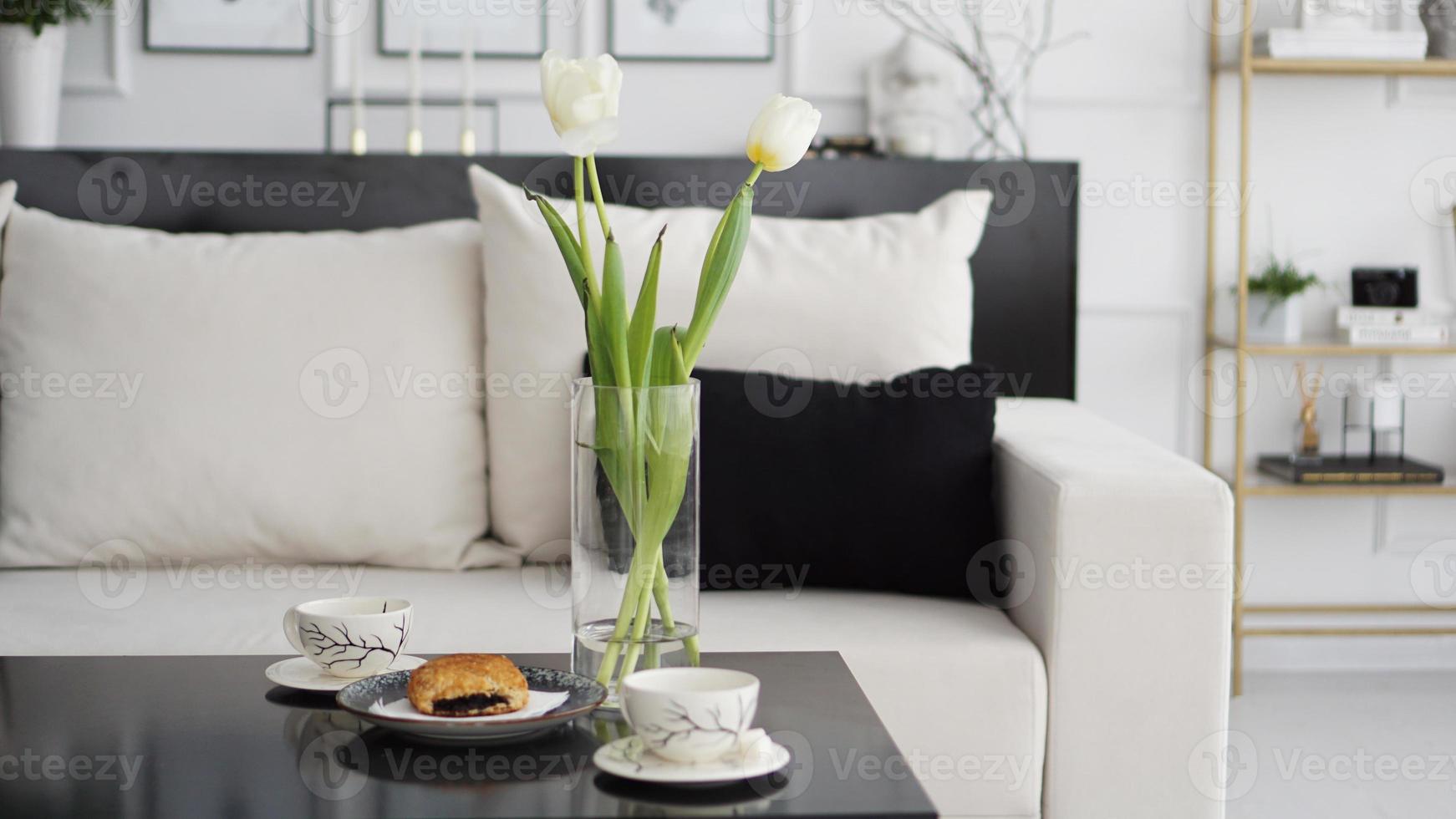 Sofa in a modern interior. On the table are a bouquet of tulips photo