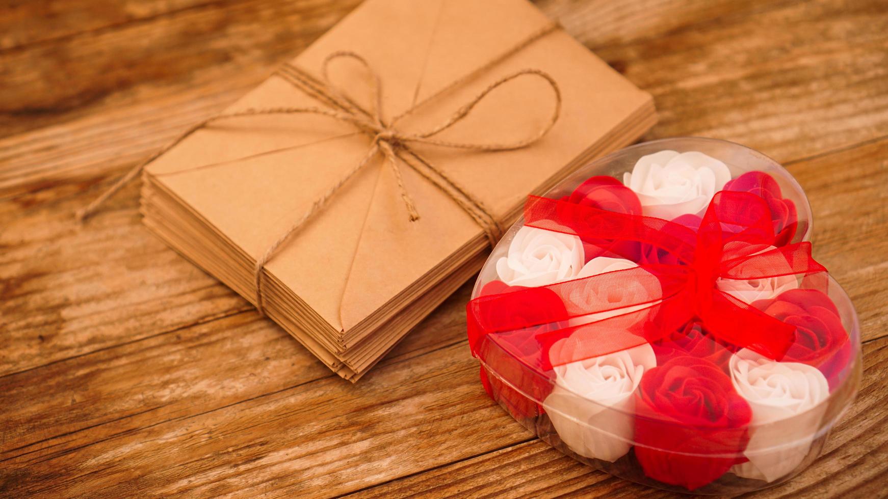 Letters in craft paper envelopes and a gift of roses photo