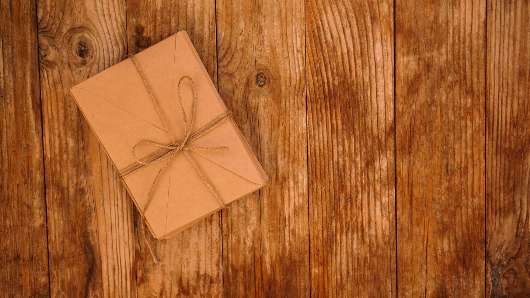 Envelopes from kraft paper tied with string on a wooden background photo