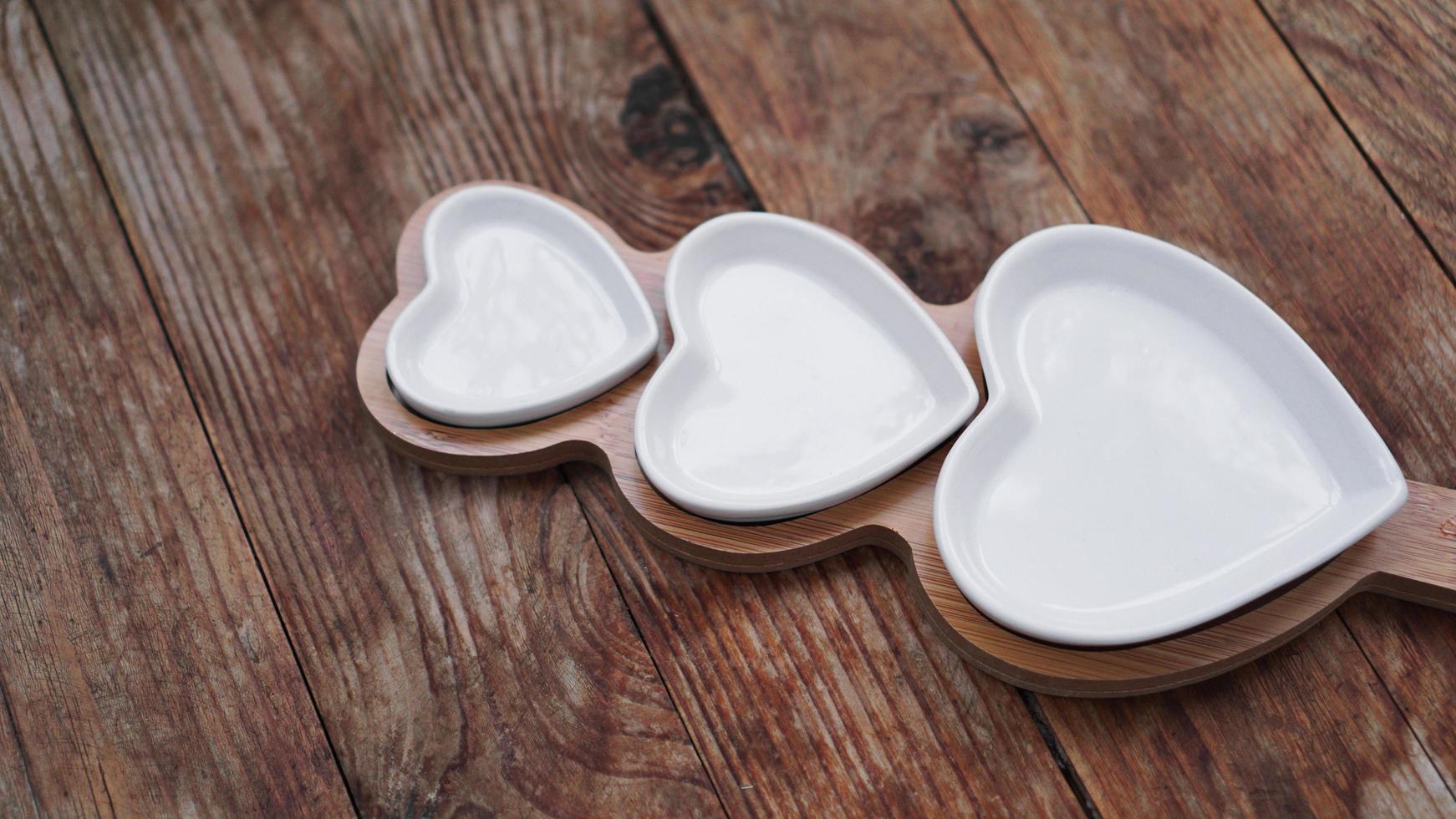 Heart shaped plates on wooden table photo