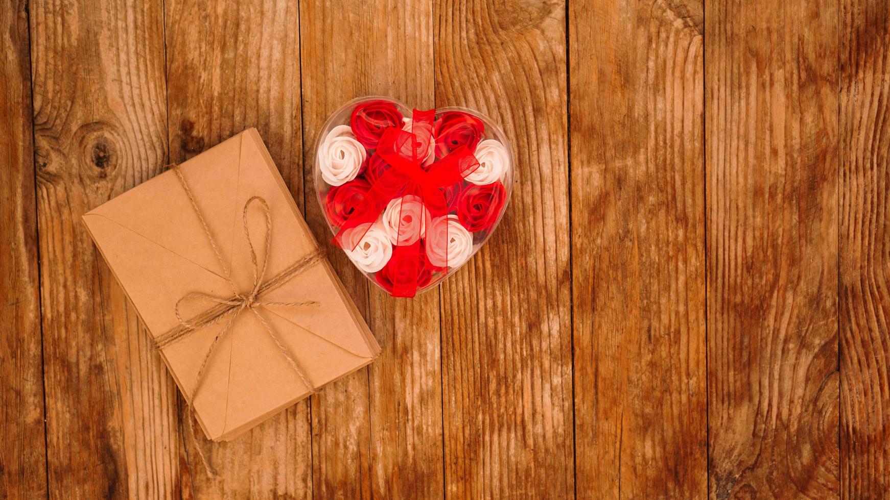cartas en sobres de papel artesanal y un regalo de rosas foto
