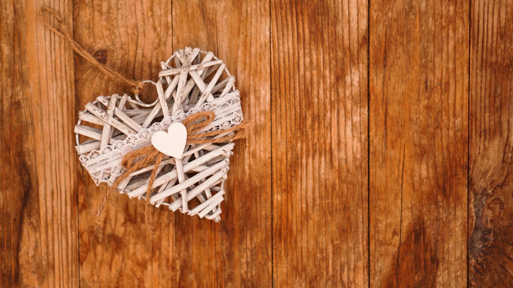 White hand made heart on wooden background photo