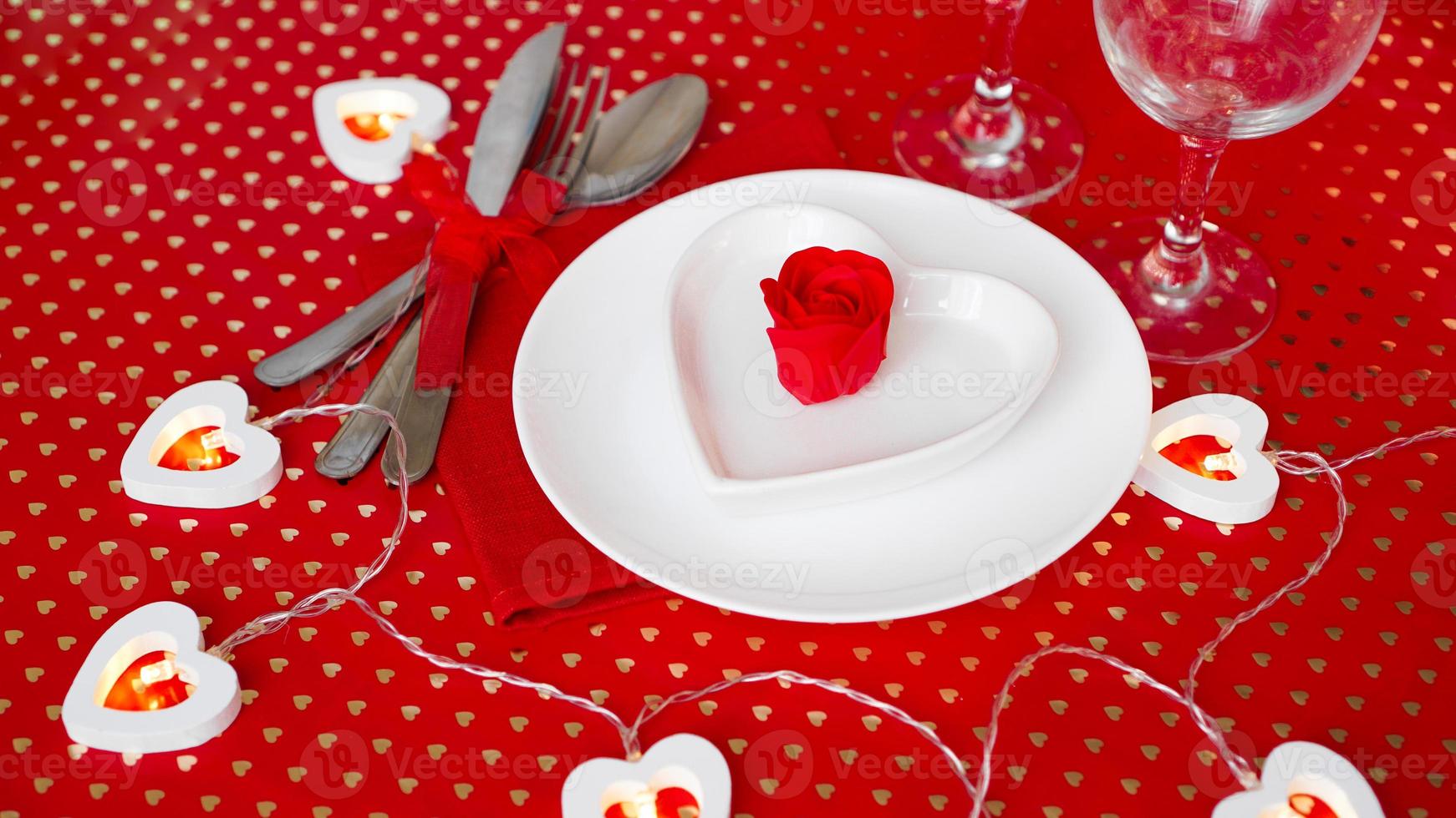 un plato blanco con cuchillo y tenedor sobre un fondo rojo brillante foto