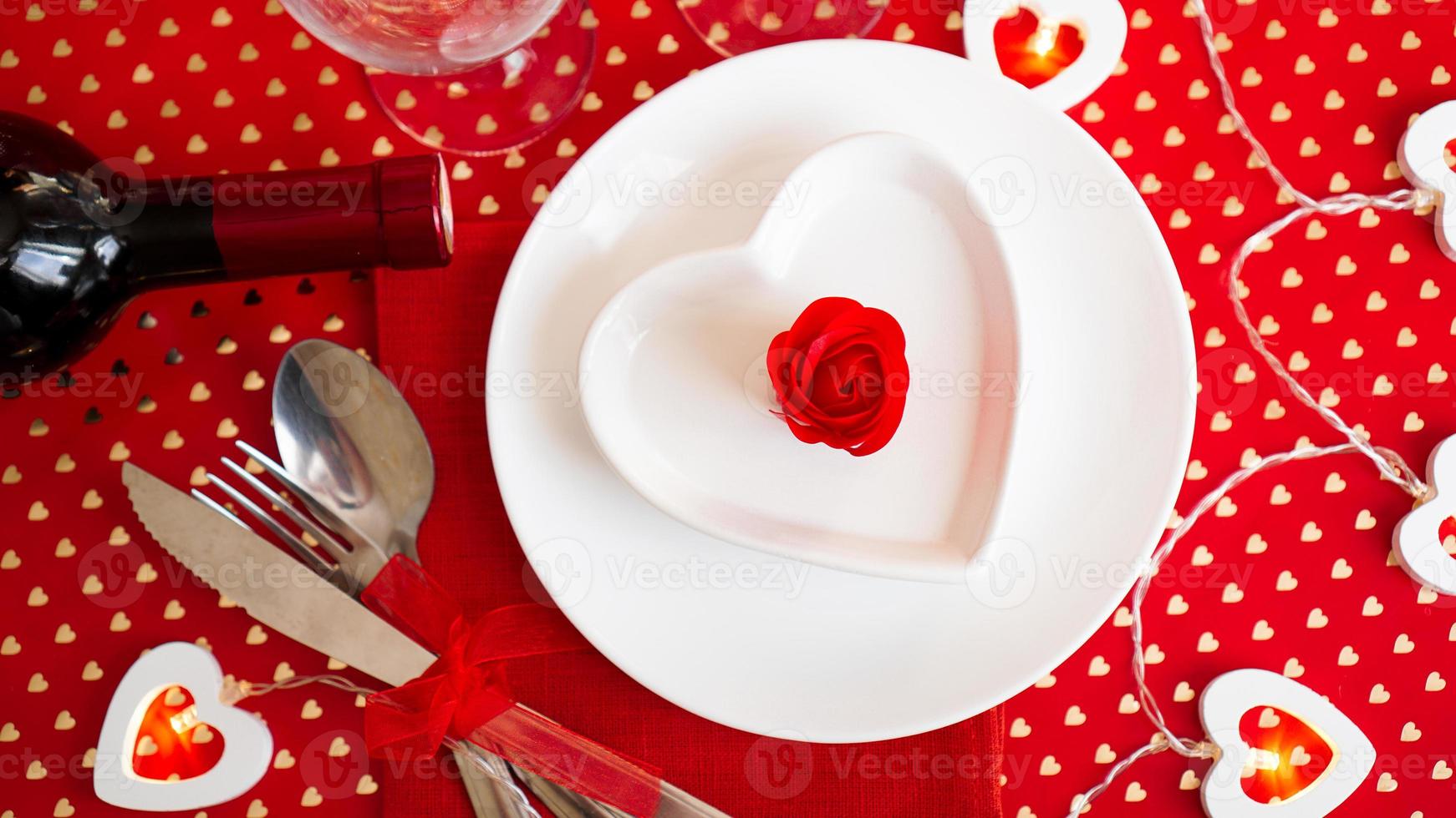 A white plate with a knife and fork on a bright red photo