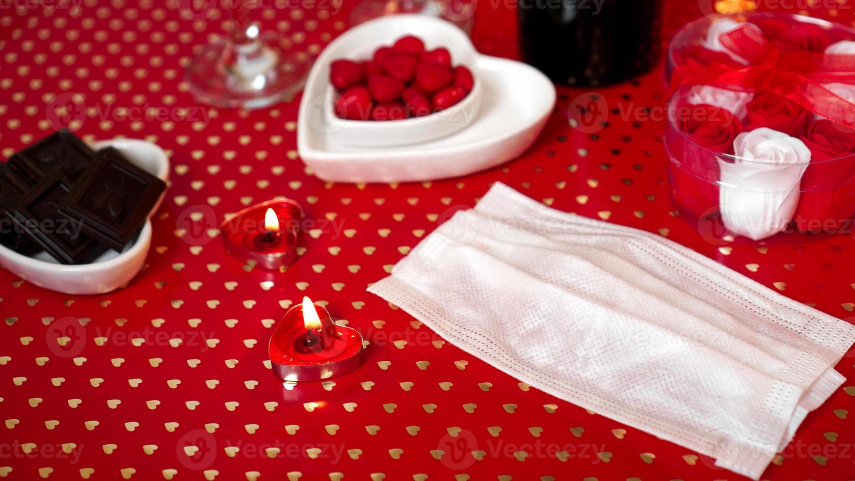 tabla de concepto del día de San Valentín. cena romantica con mascarilla medica foto