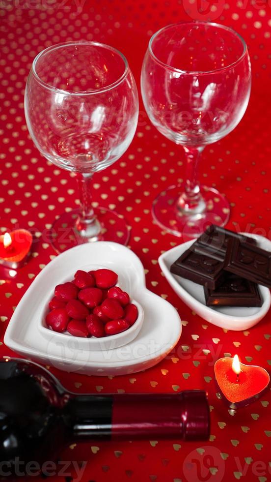 día de San Valentín. botella de vid, vasos, rosas rojas foto
