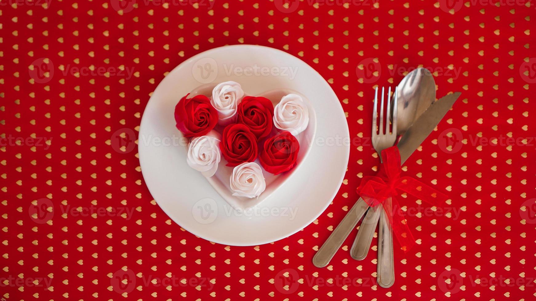 un plato blanco con cuchillo y tenedor sobre un fondo rojo brillante foto