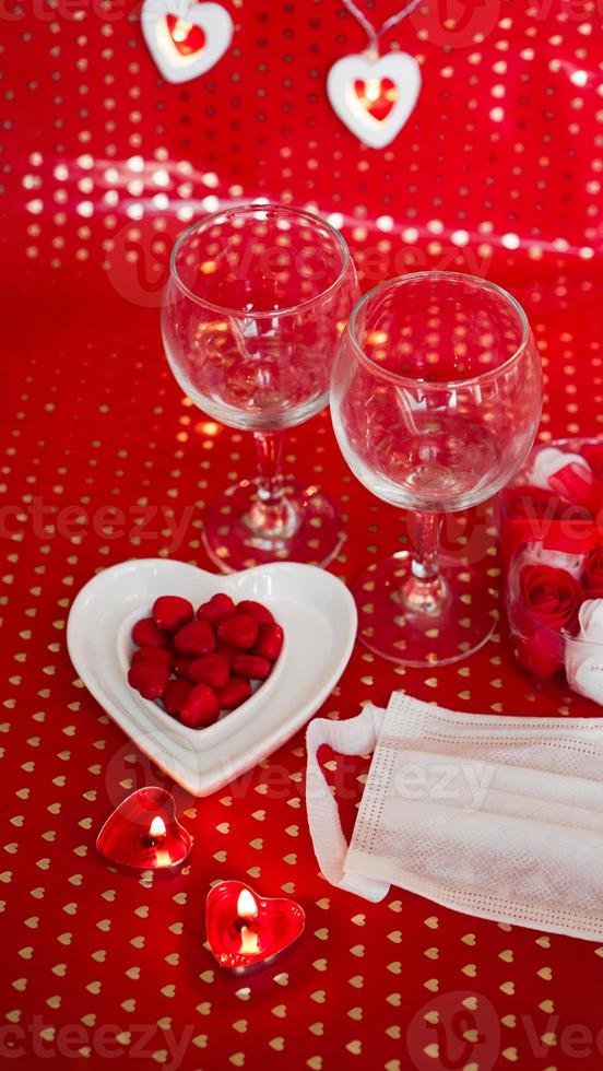 tabla de concepto del día de San Valentín. cena romantica con mascarilla medica foto